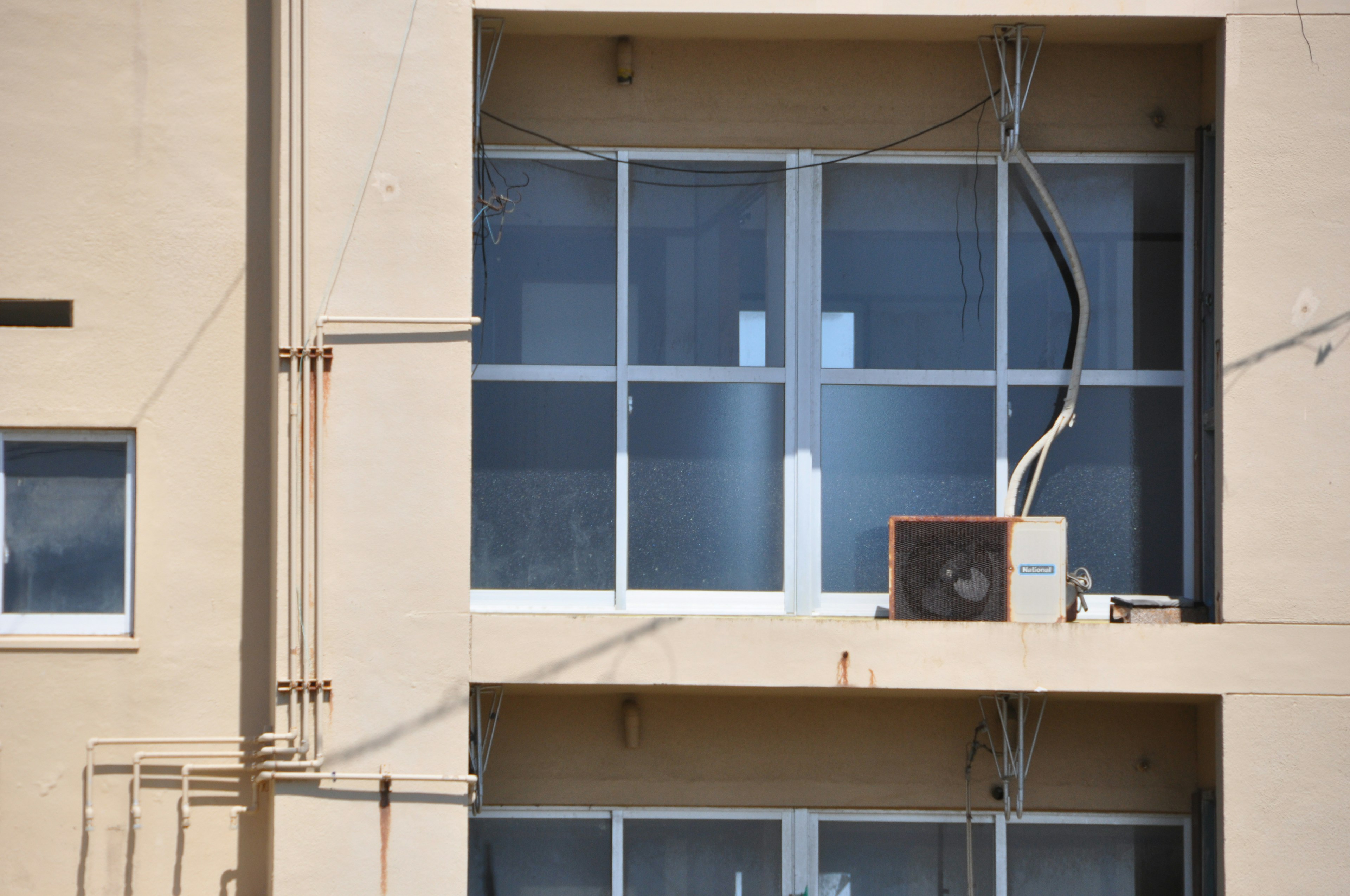 Vue extérieure d'un bâtiment avec des fenêtres et une unité de climatisation