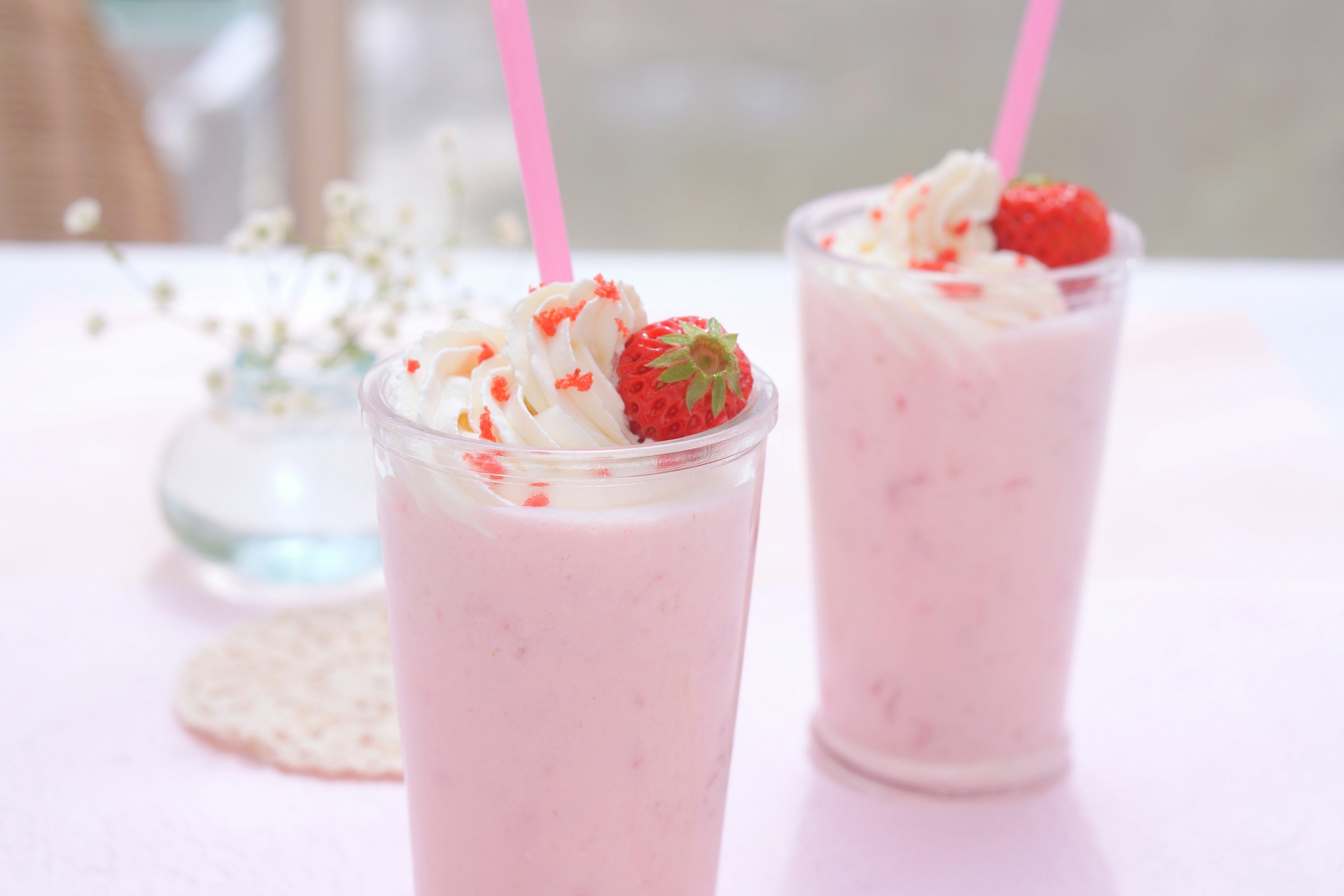 Batido rosa decorado con crema batida y fresas