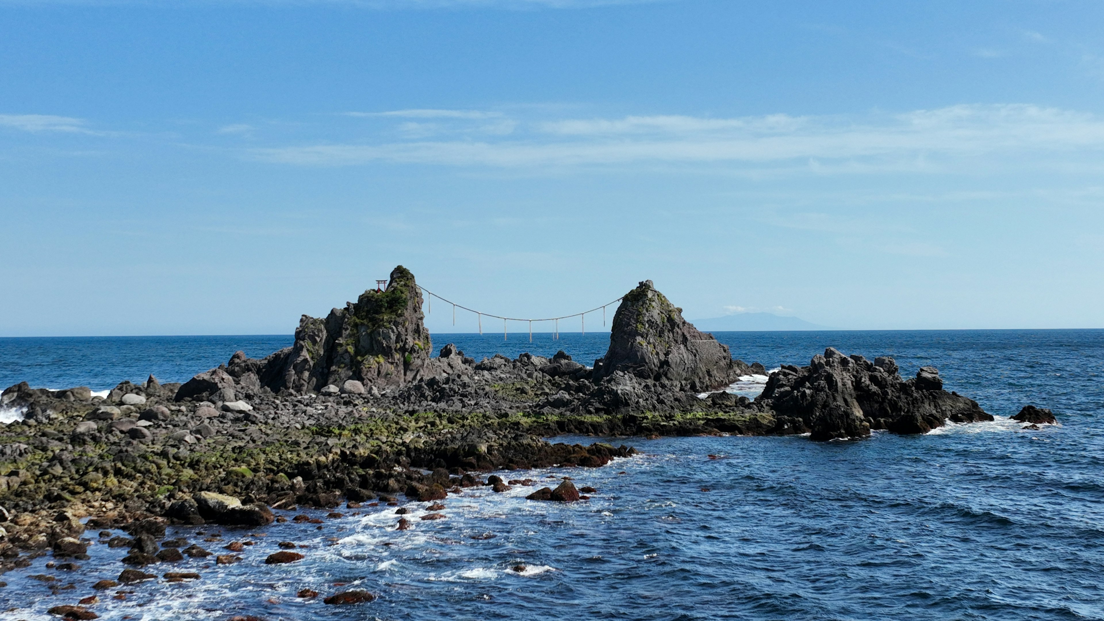 Pemandangan pantai dengan laut biru dan formasi batu