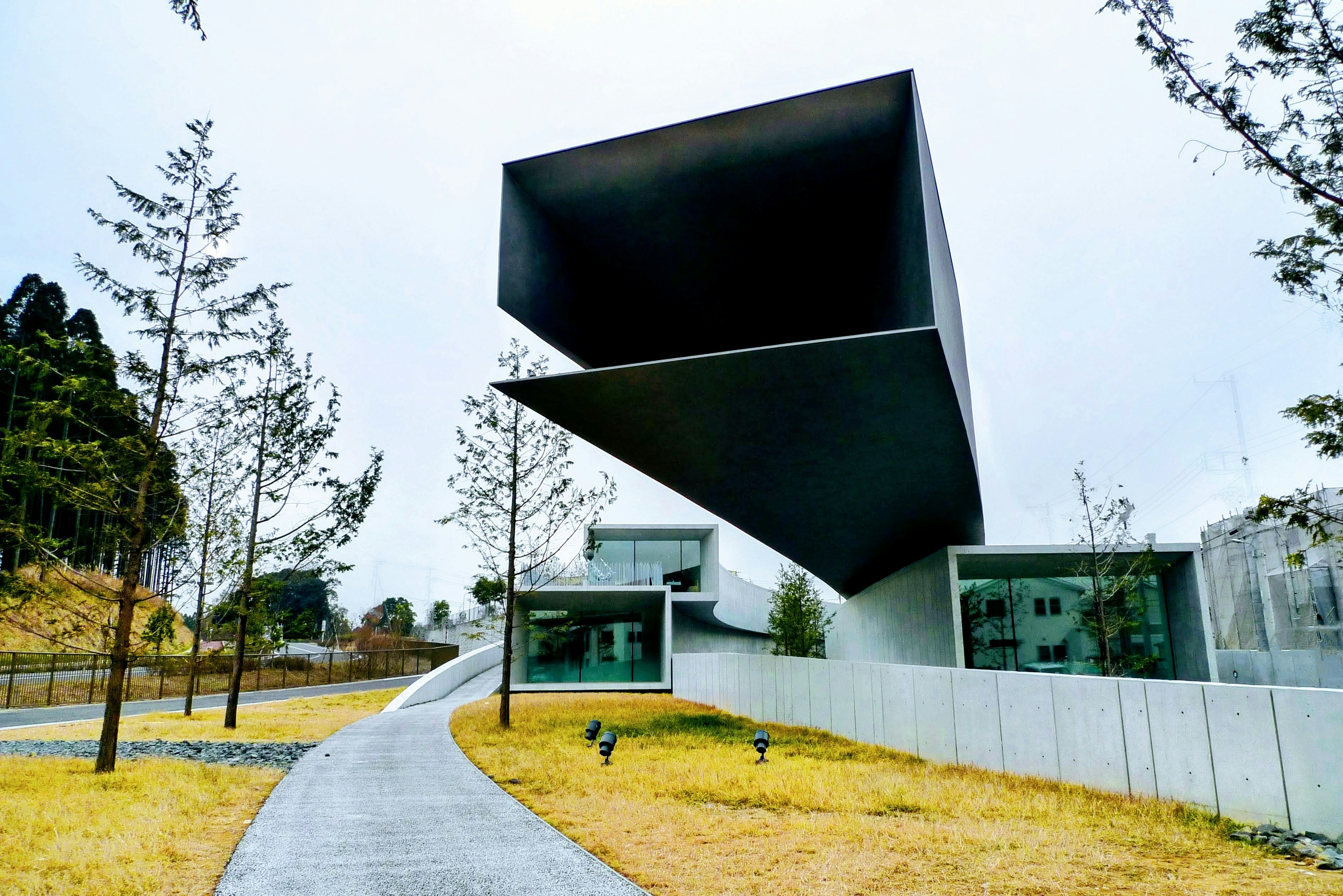 Modern architectural design featuring a cantilevered structure and landscaped pathway