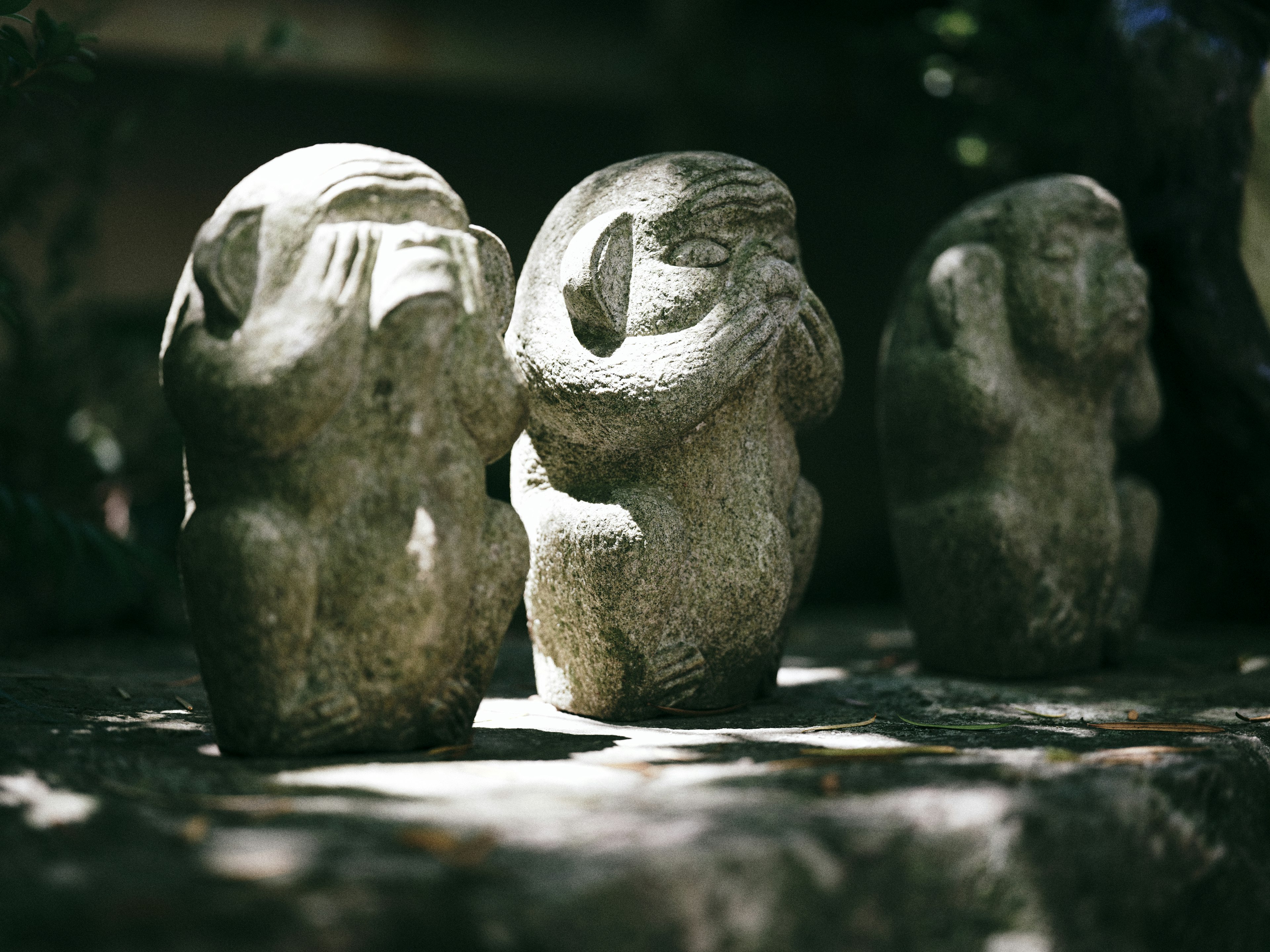 Imagen de tres figuras de piedra cubriendo sus ojos