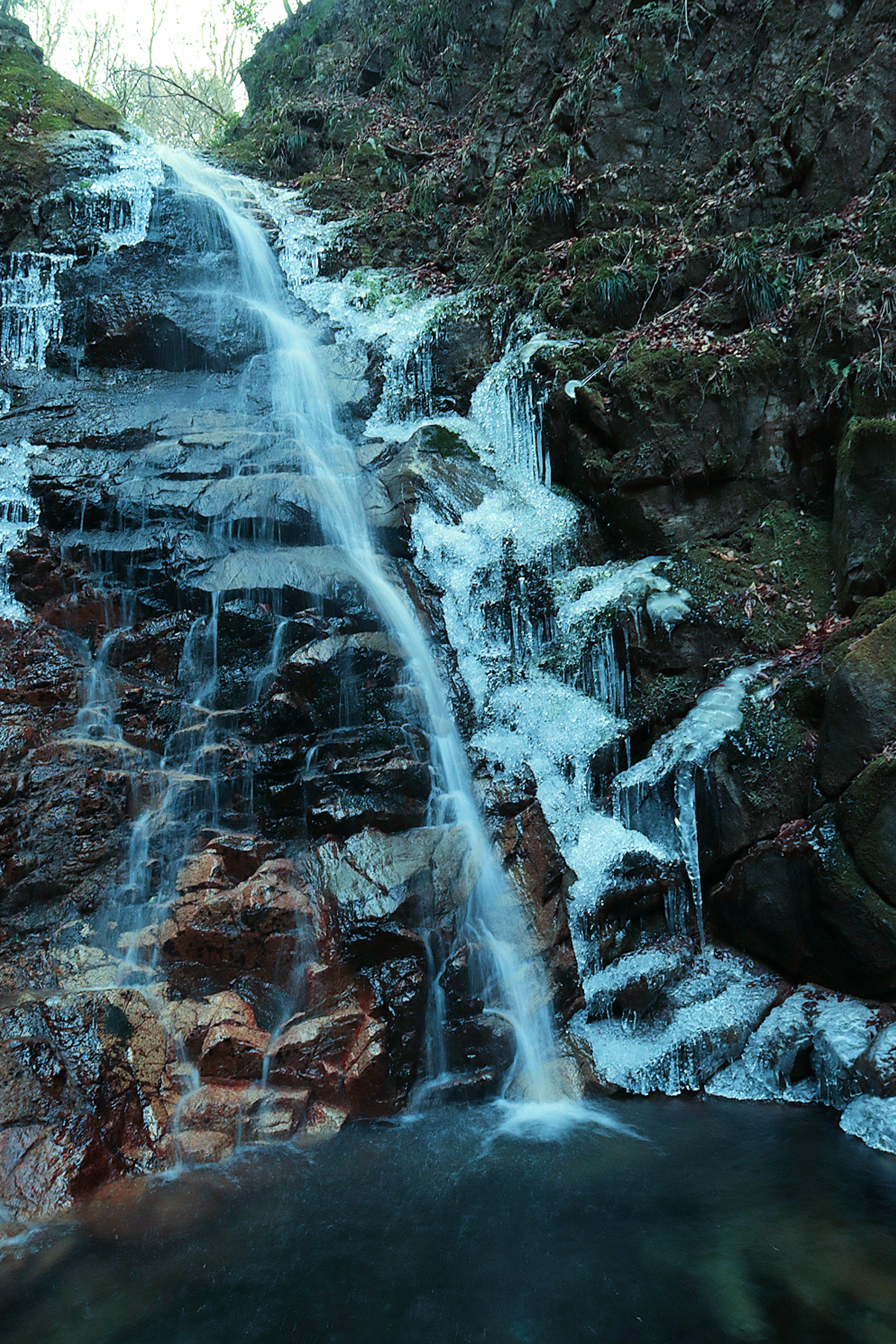 Una bella scena naturale con una cascata che scorre su un terreno roccioso