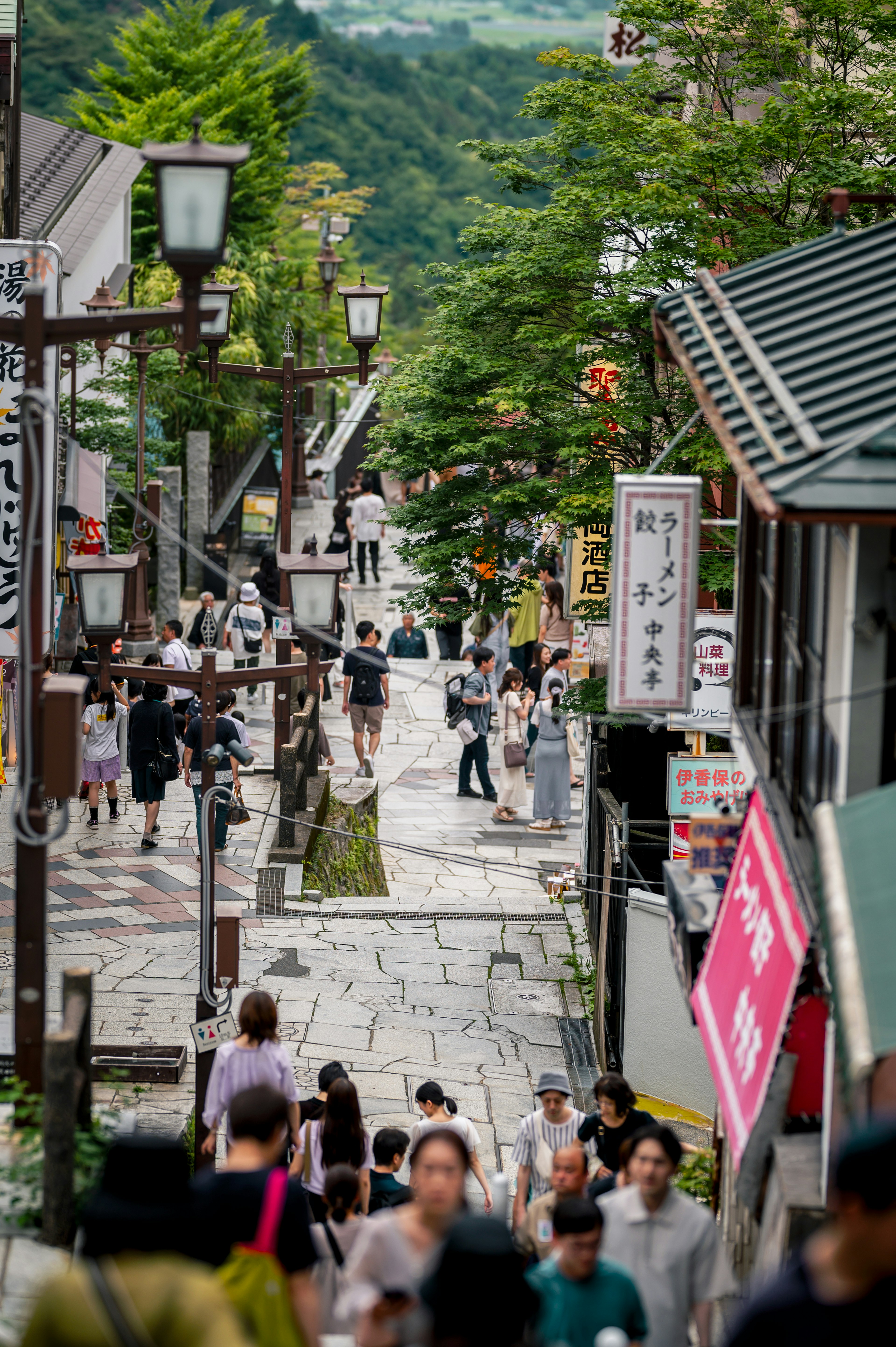 Bustling street scene with people walking on cobblestone path