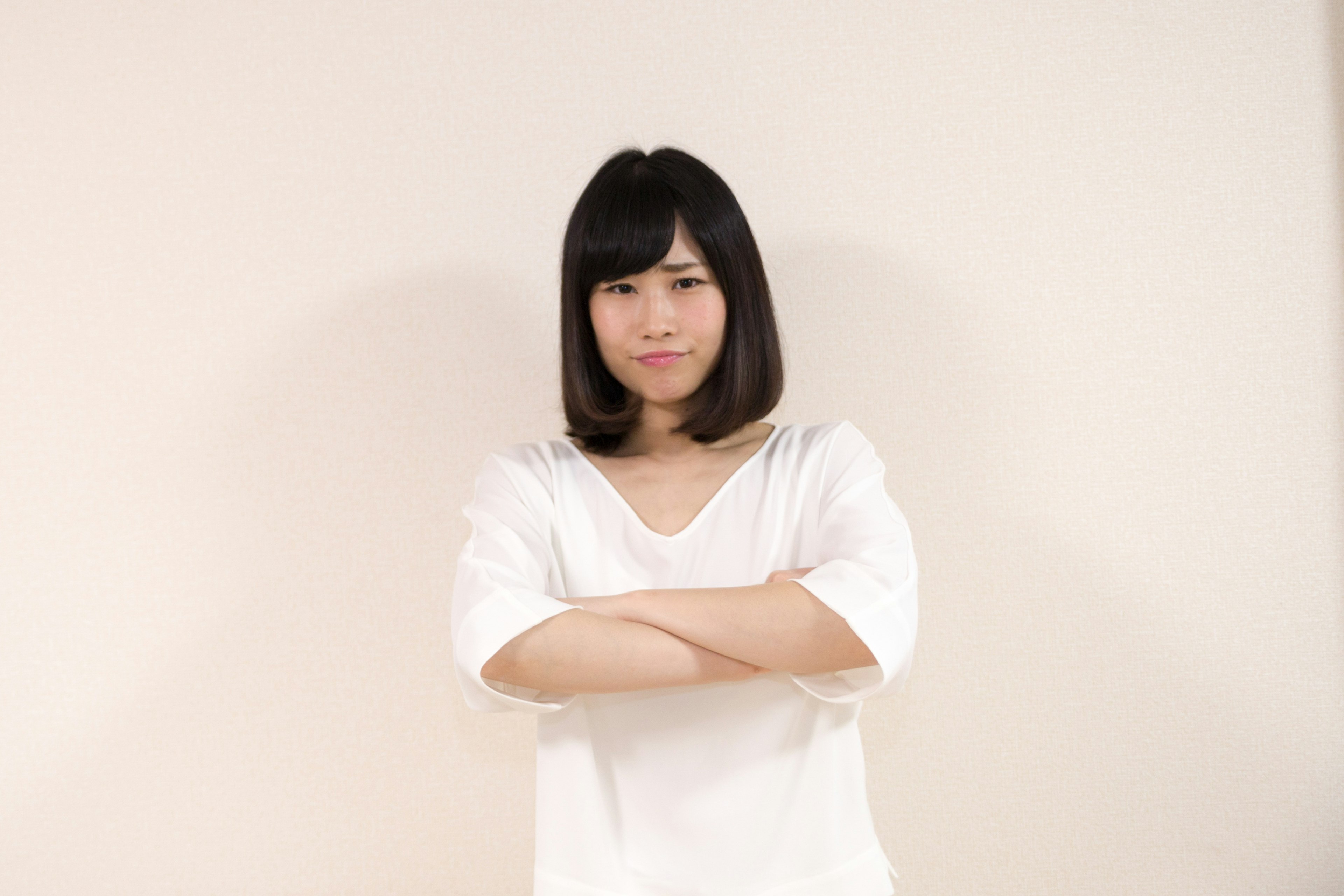 Young woman with crossed arms wearing a white shirt