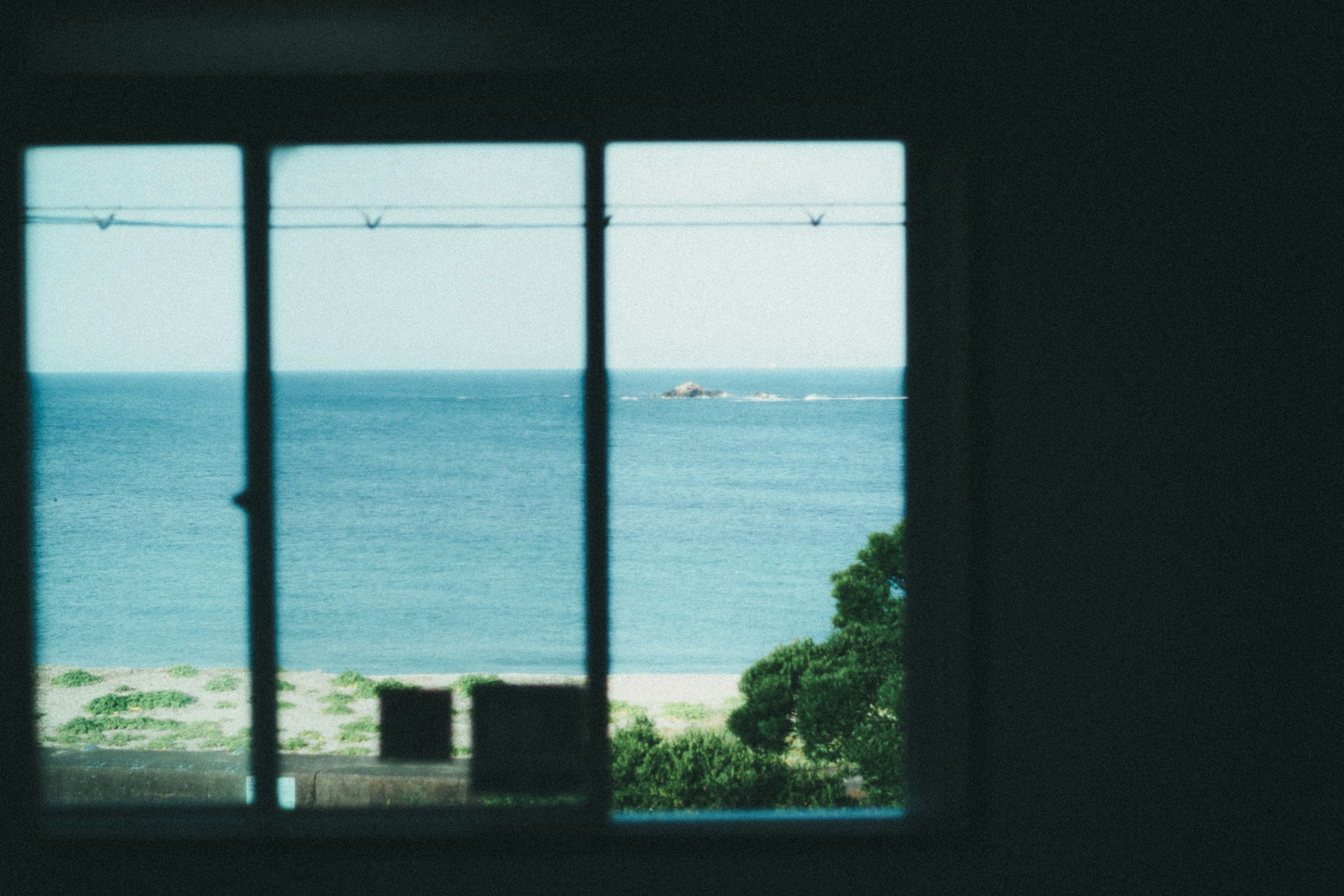 View of the sea and a boat through a window