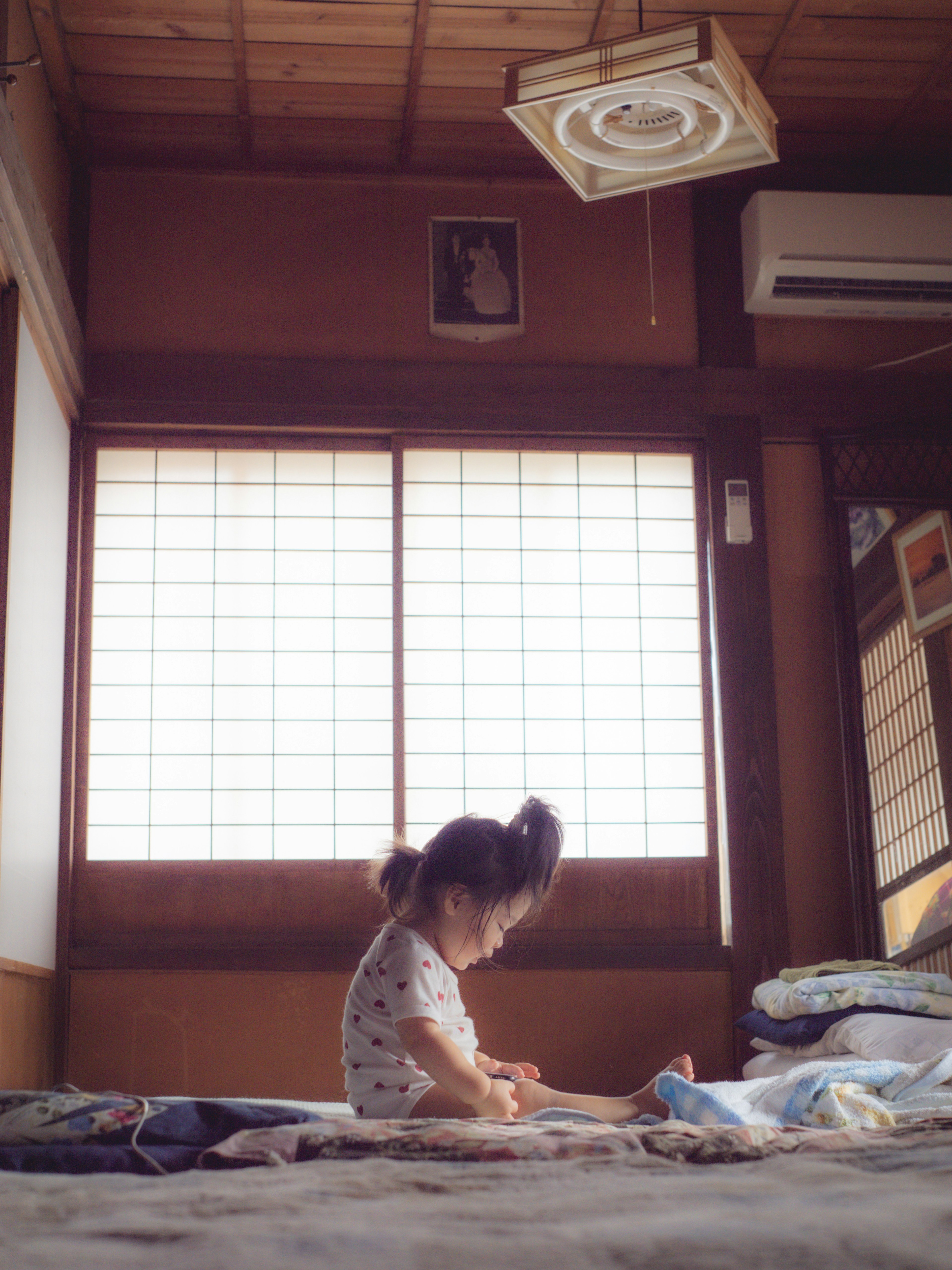 Kind sitzt auf dem Boden in einem traditionellen japanischen Raum Sanftes Licht, das durch das Fenster strömt