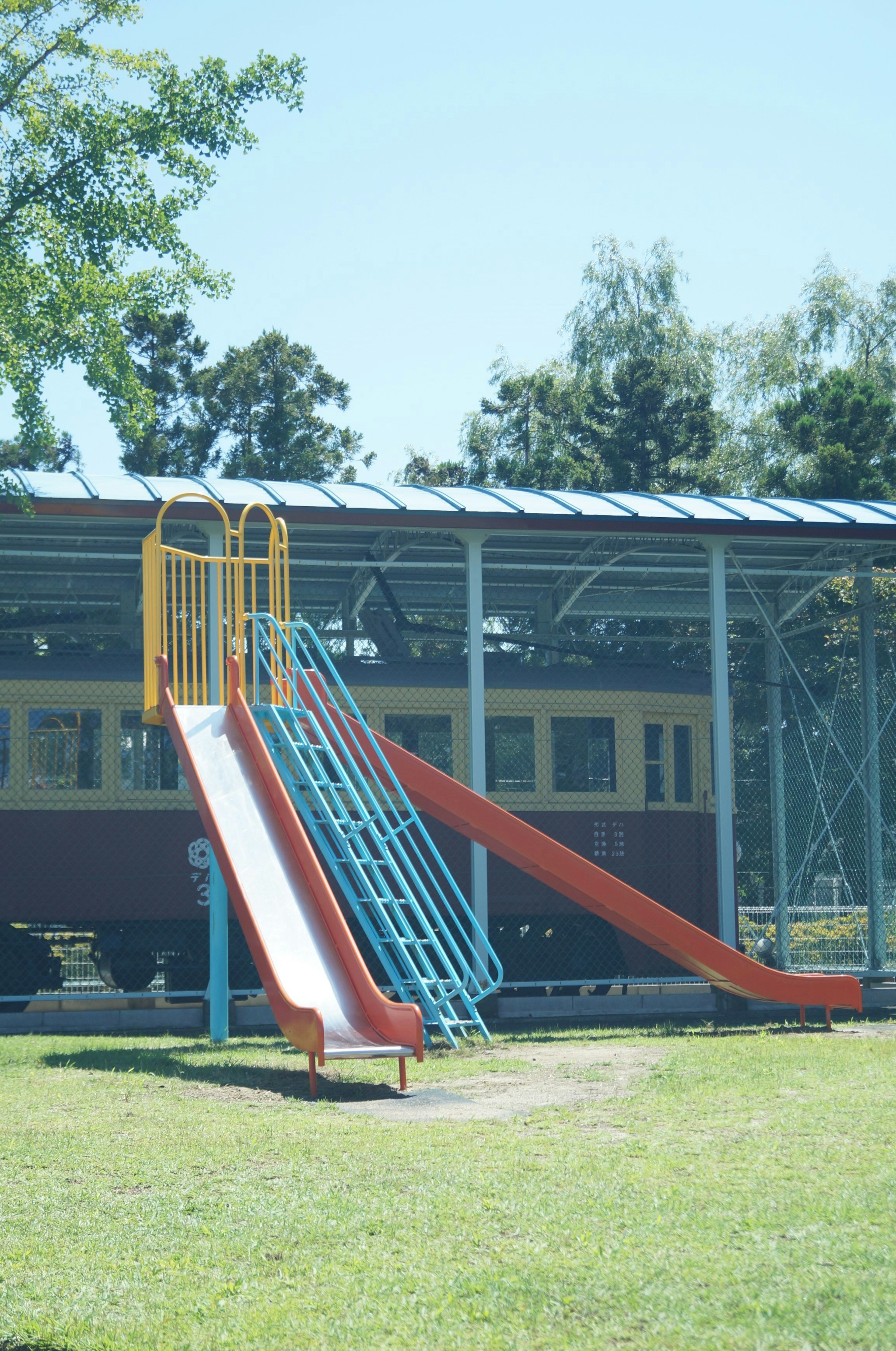 Escena de parque con un tobogán azul y rojo