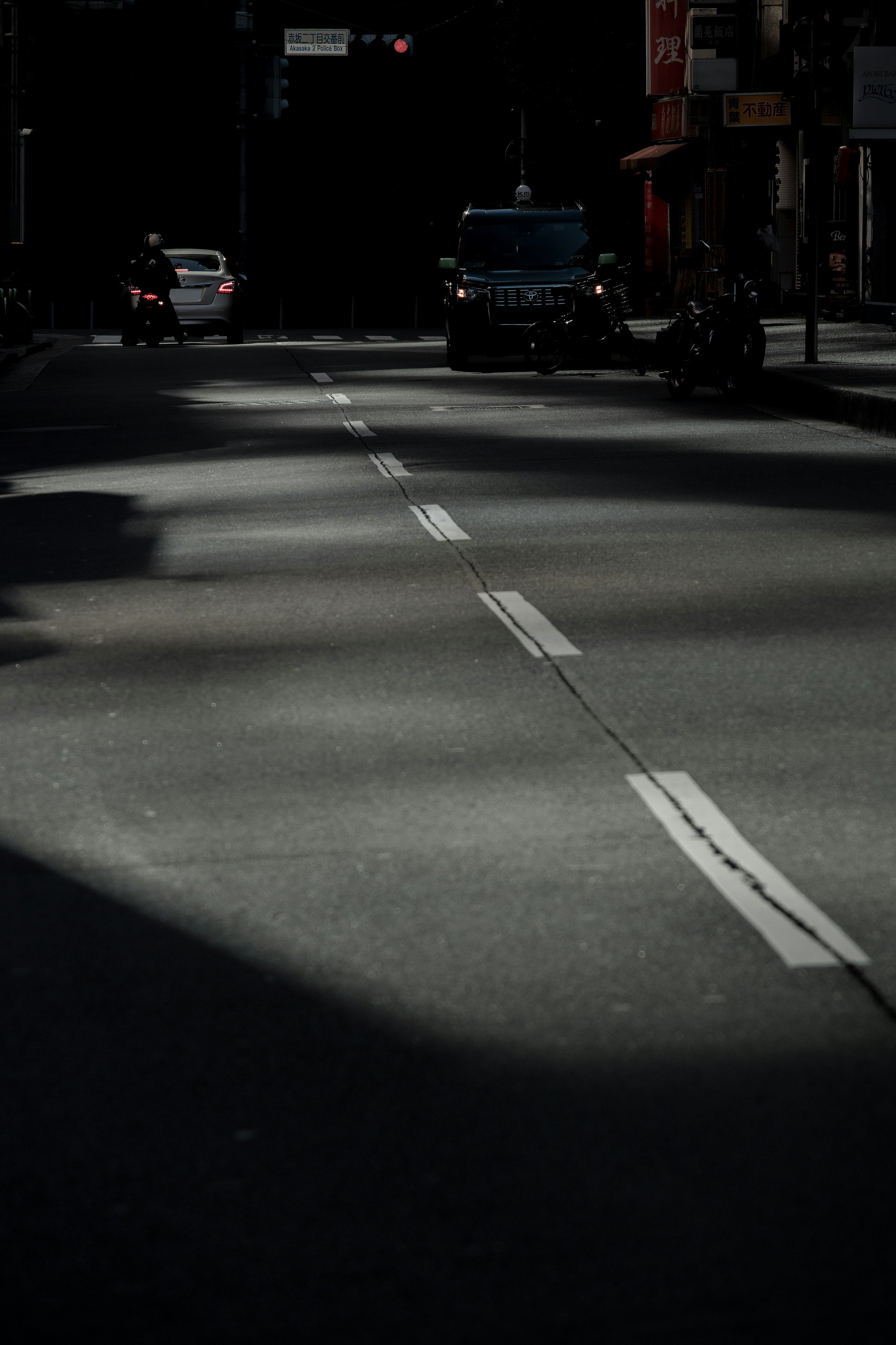 Strada debolmente illuminata con ombre e segnaletica bianca