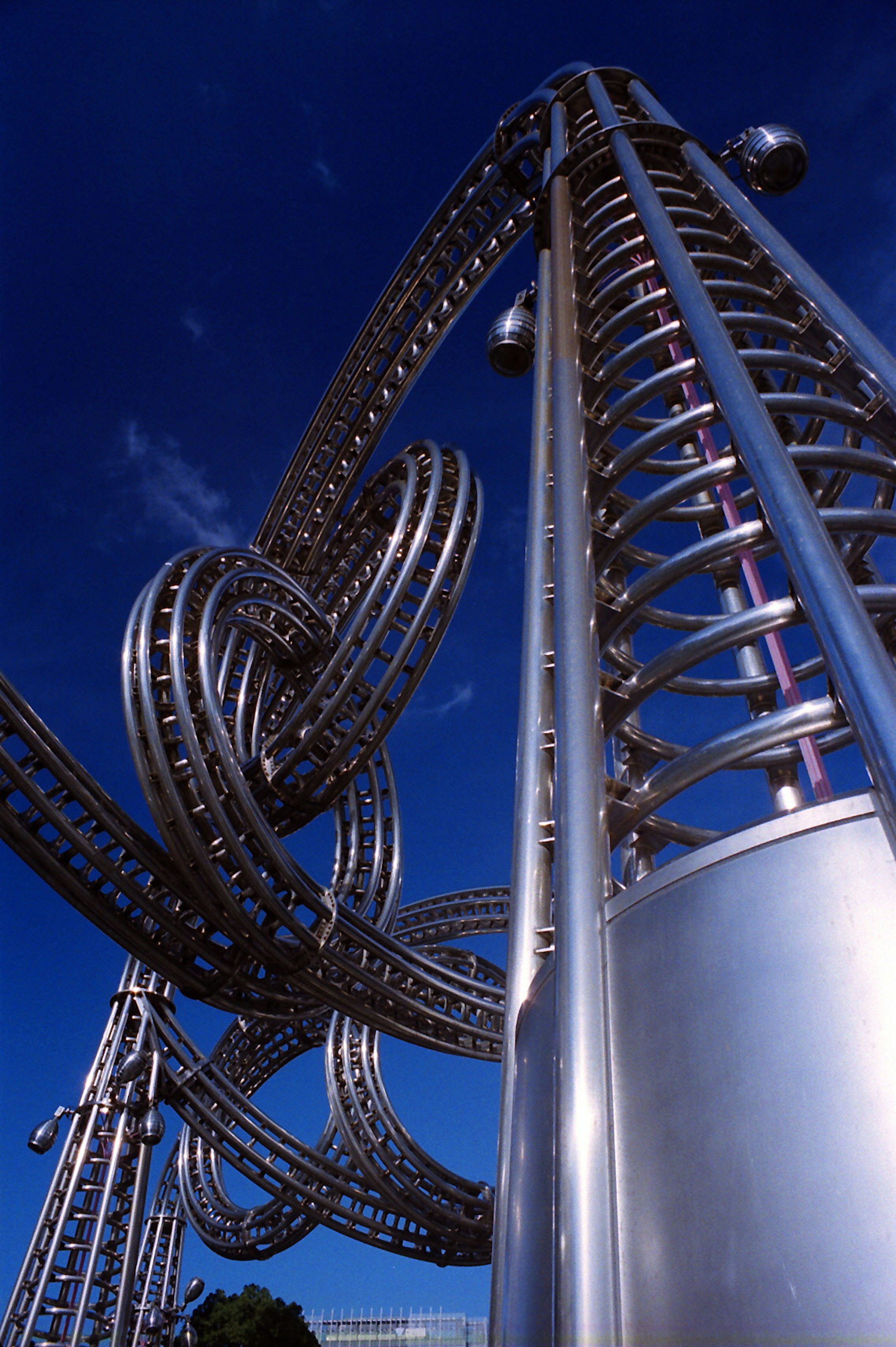 Close-up of a metallic spiral structure under a blue sky