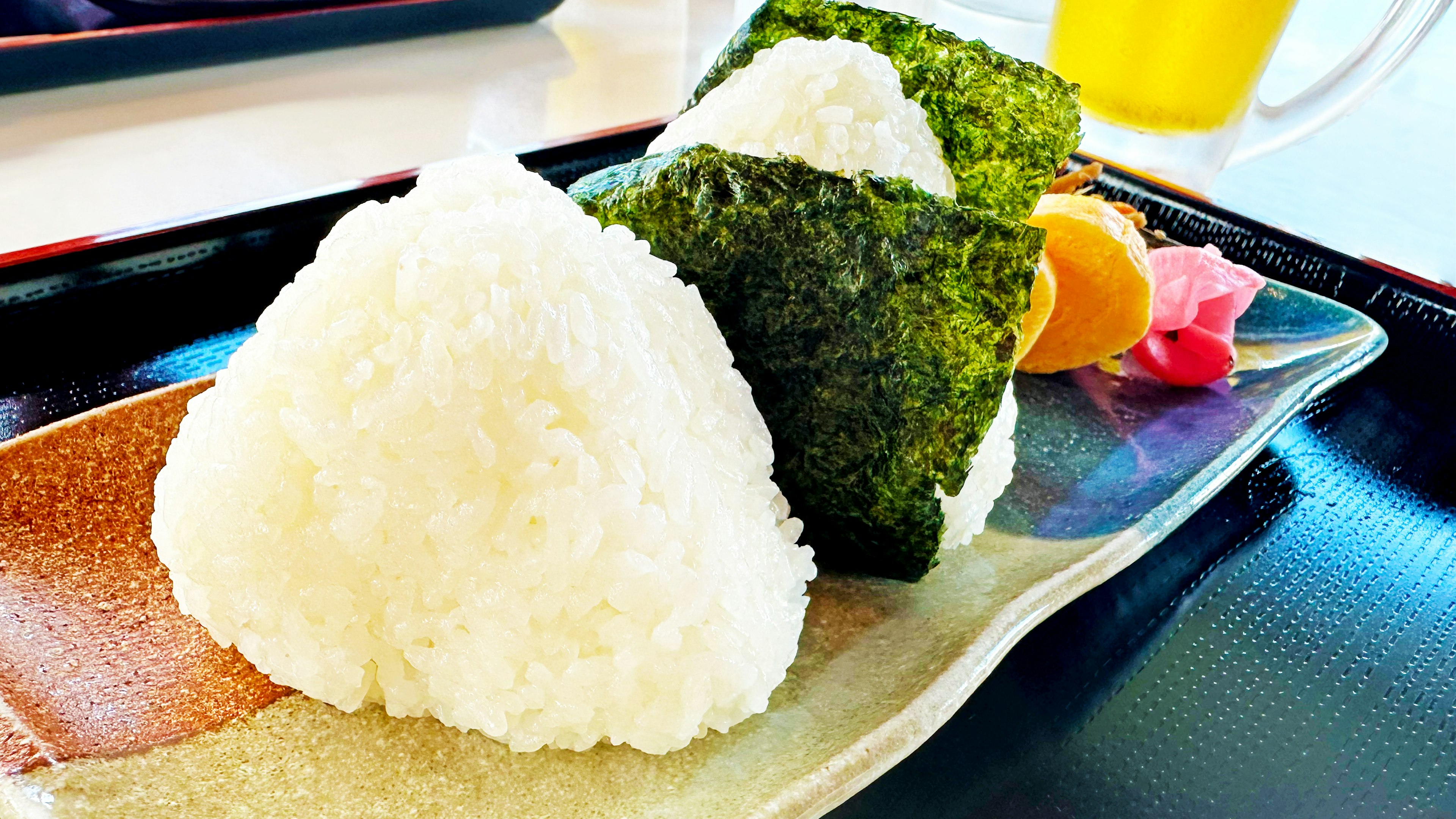 A beautifully arranged plate of onigiri and nori with garnishes