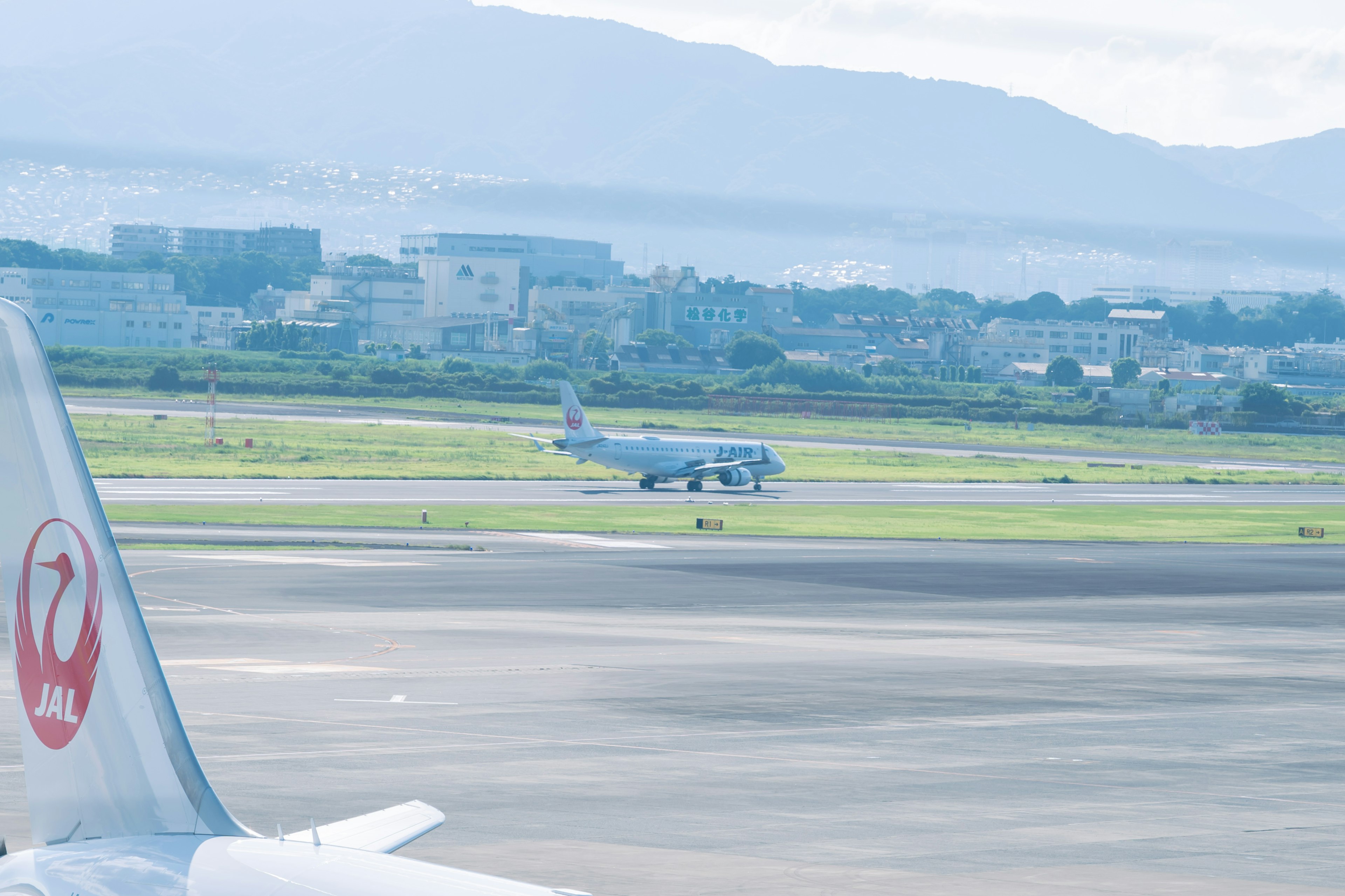 Avión preparándose para despegar en el aeropuerto con montañas al fondo