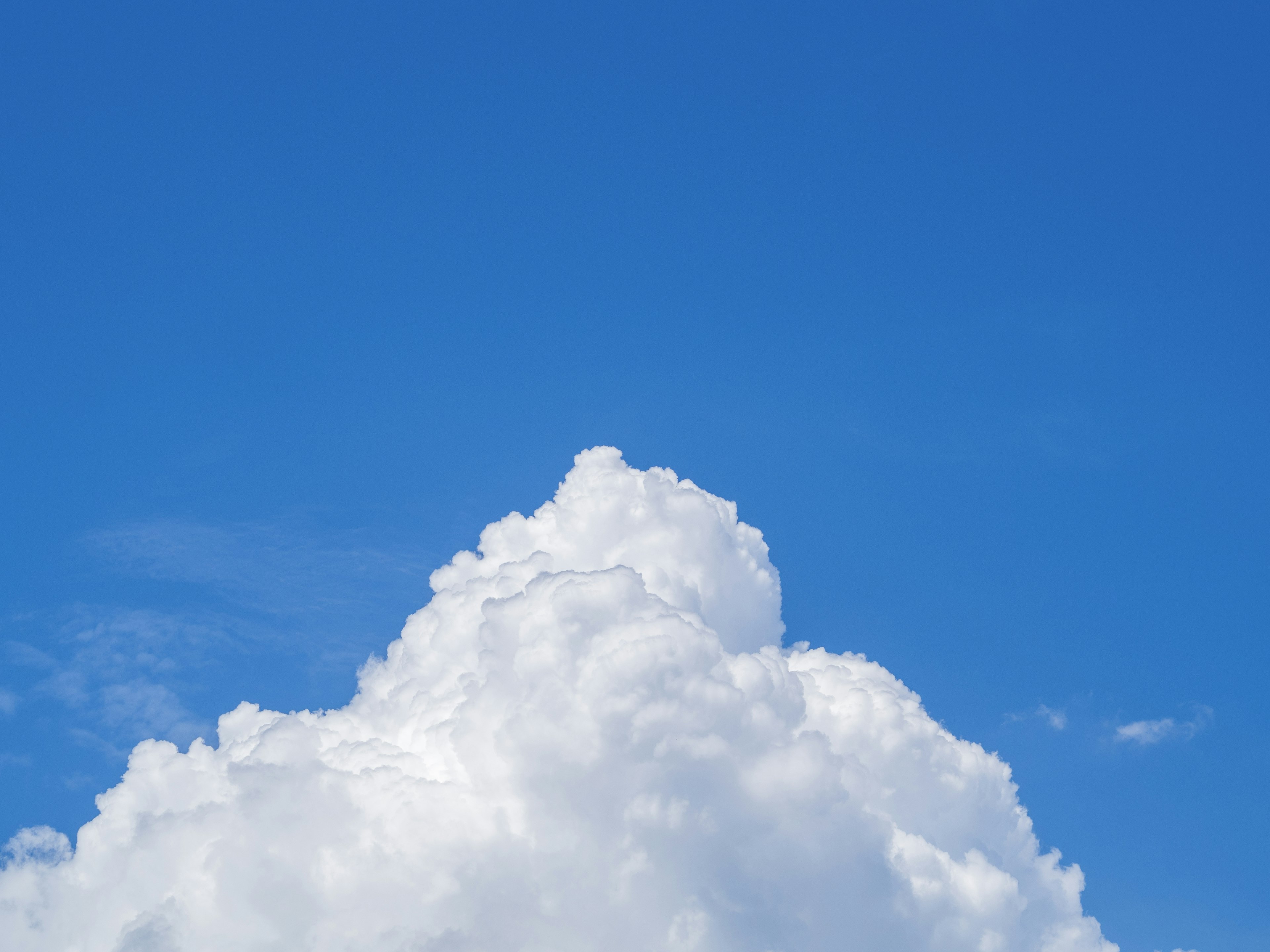 Awan putih besar mengapung di langit biru