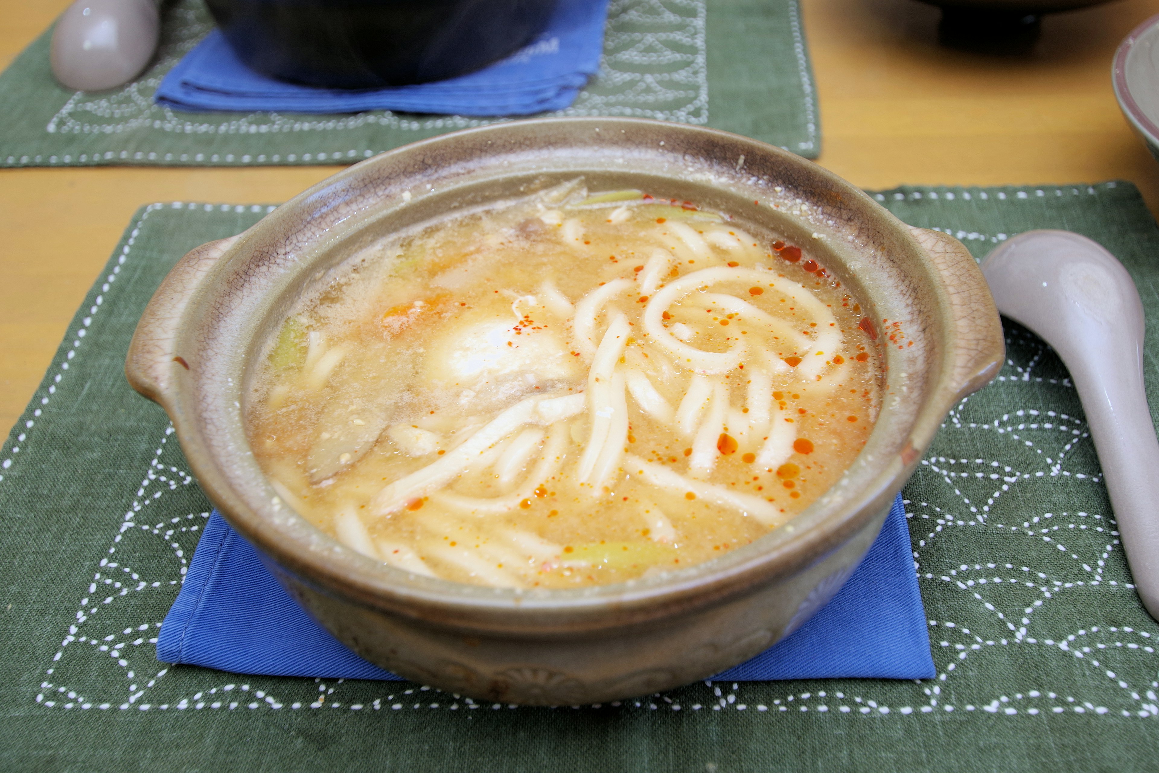 一碗溫熱的烏冬麵湯，配有麵條和配料