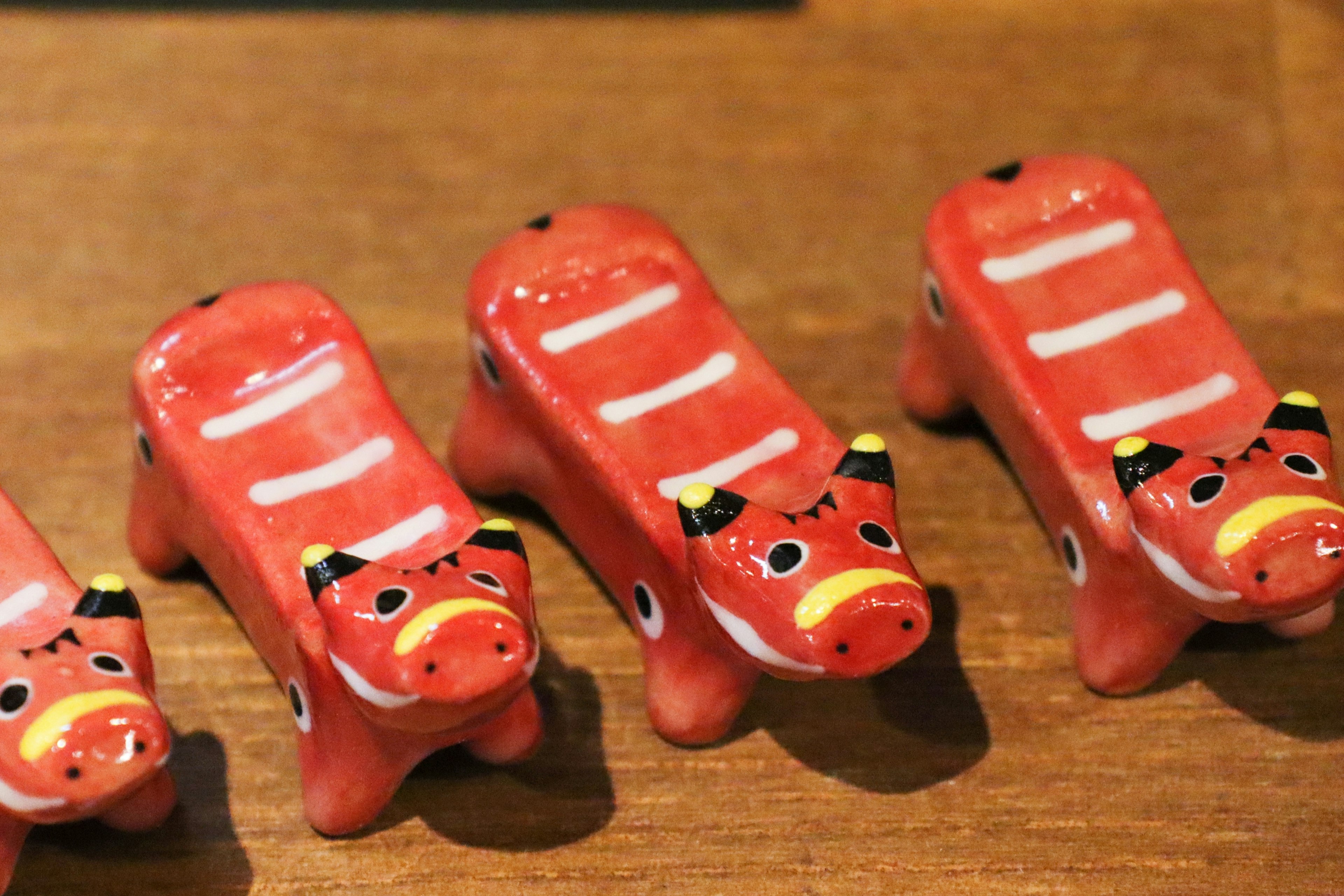 Figurines de vache en céramique rouge disposées en rangée