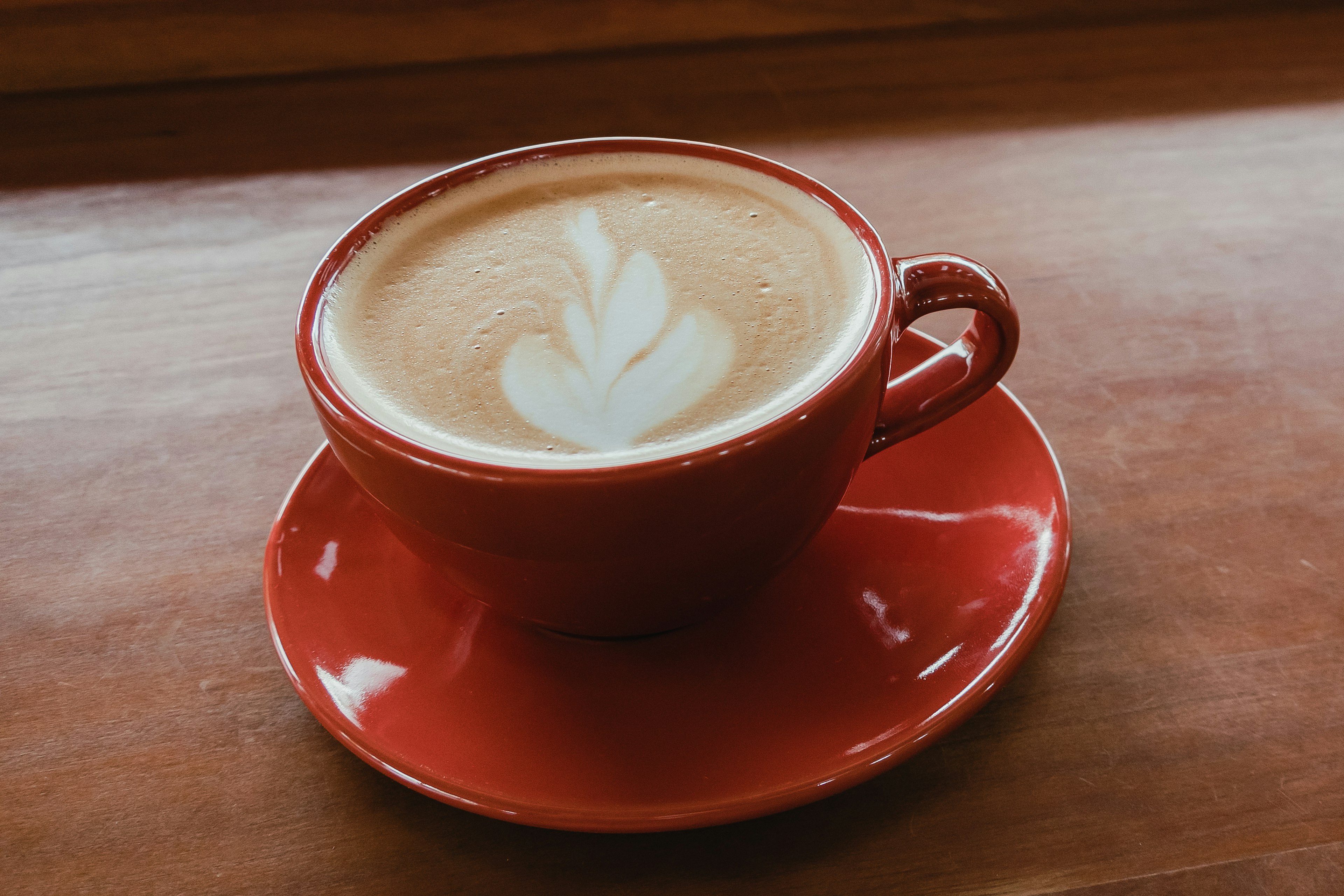 Coffee with latte art in a red cup