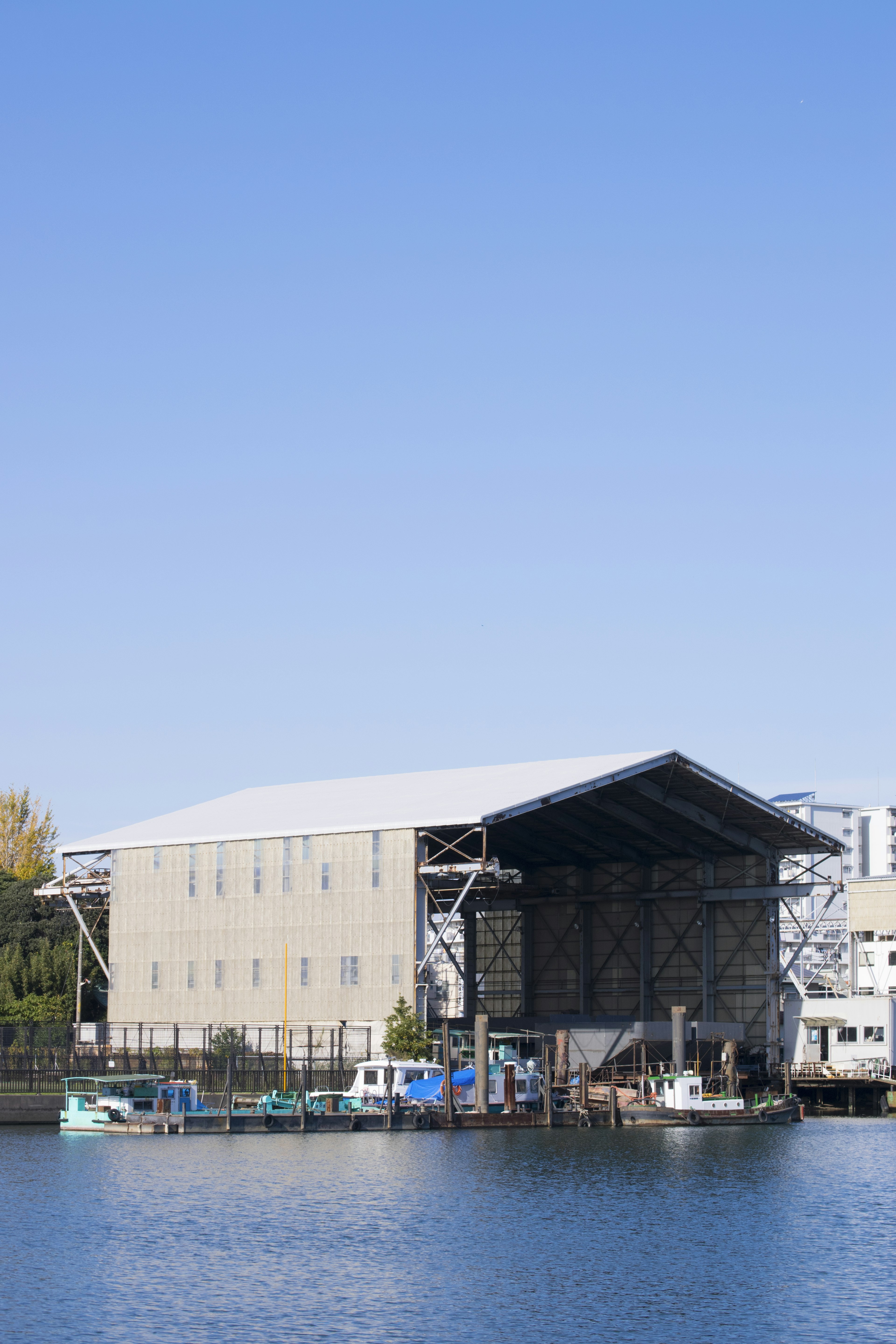 Large warehouse by the water with small boats