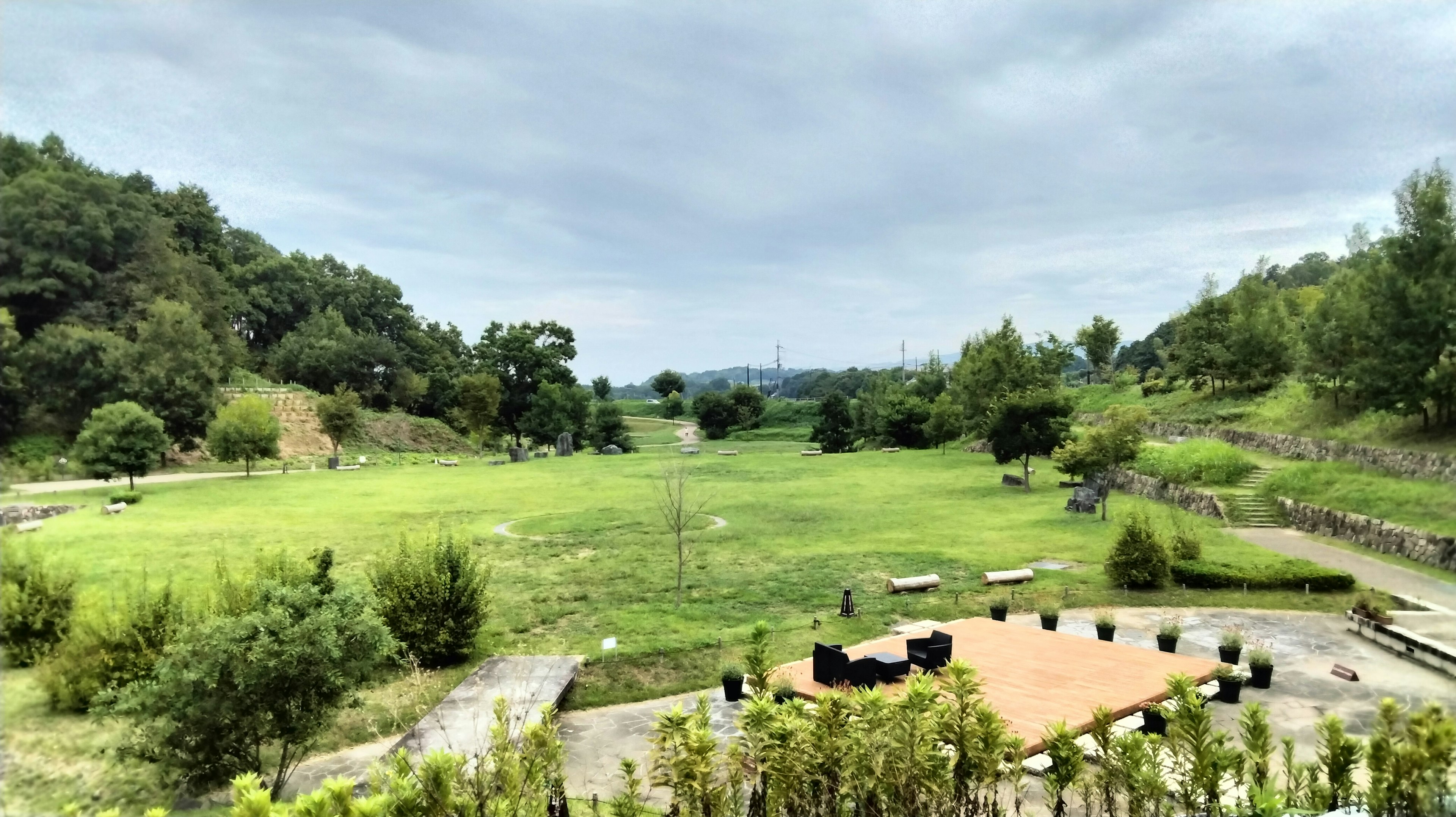 Park landscape featuring green fields and cloudy sky