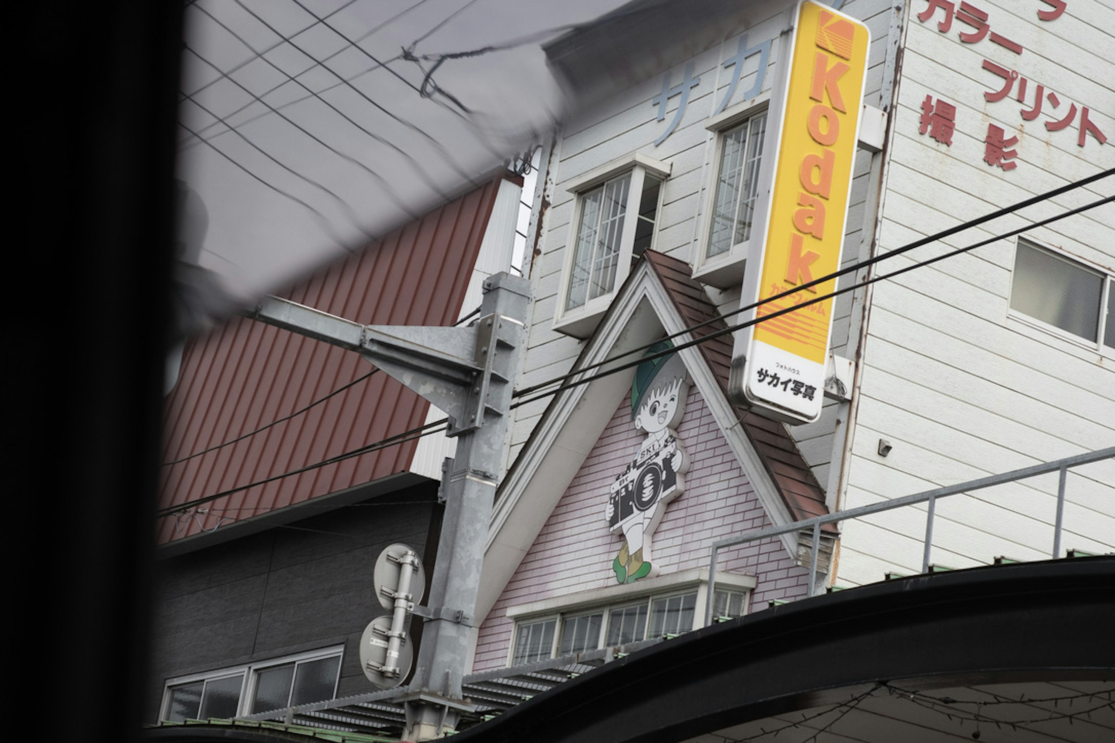 建物の外観に看板と電線が見える