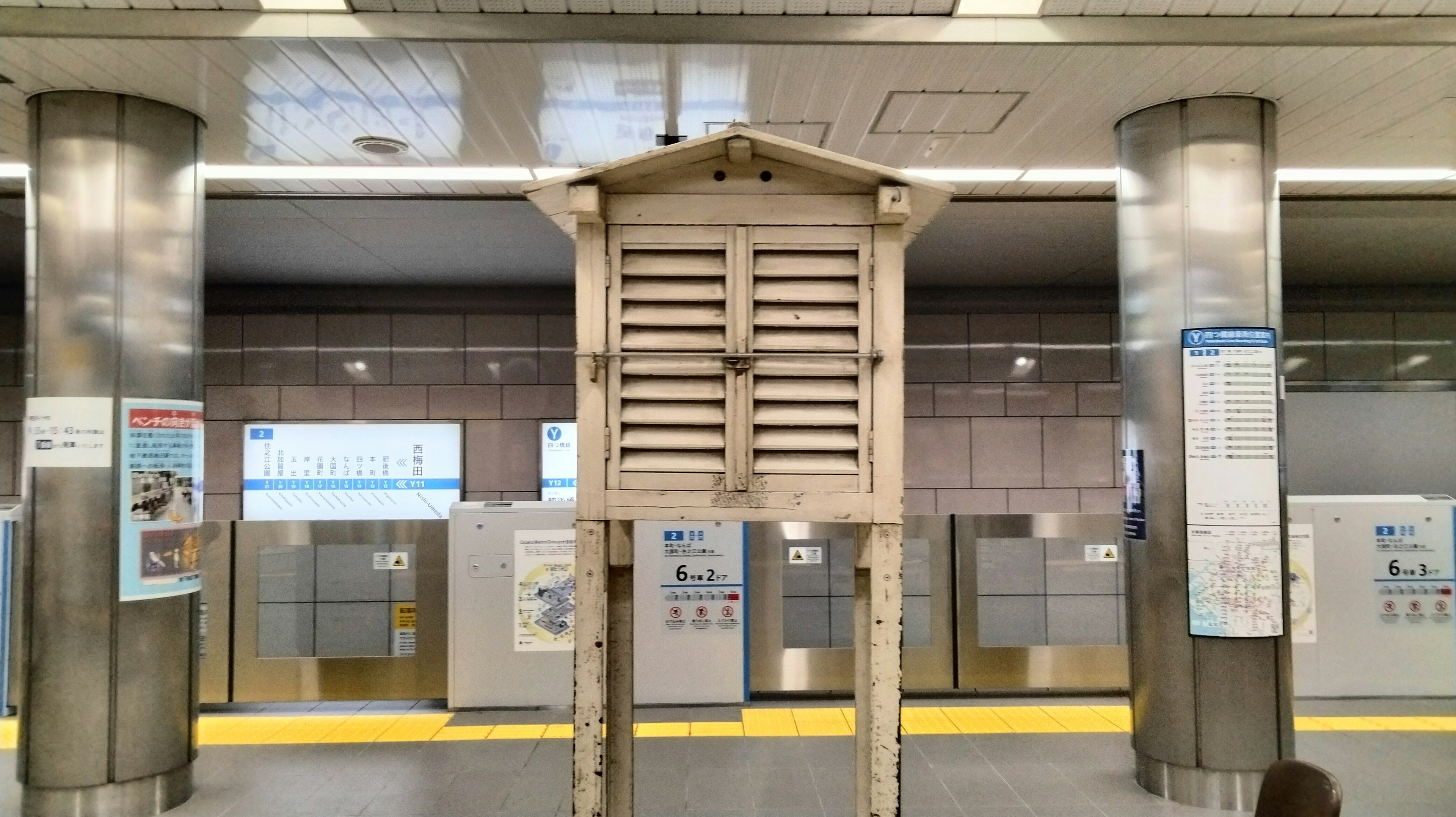 駅のプラットフォームに立つ木製の掲示板