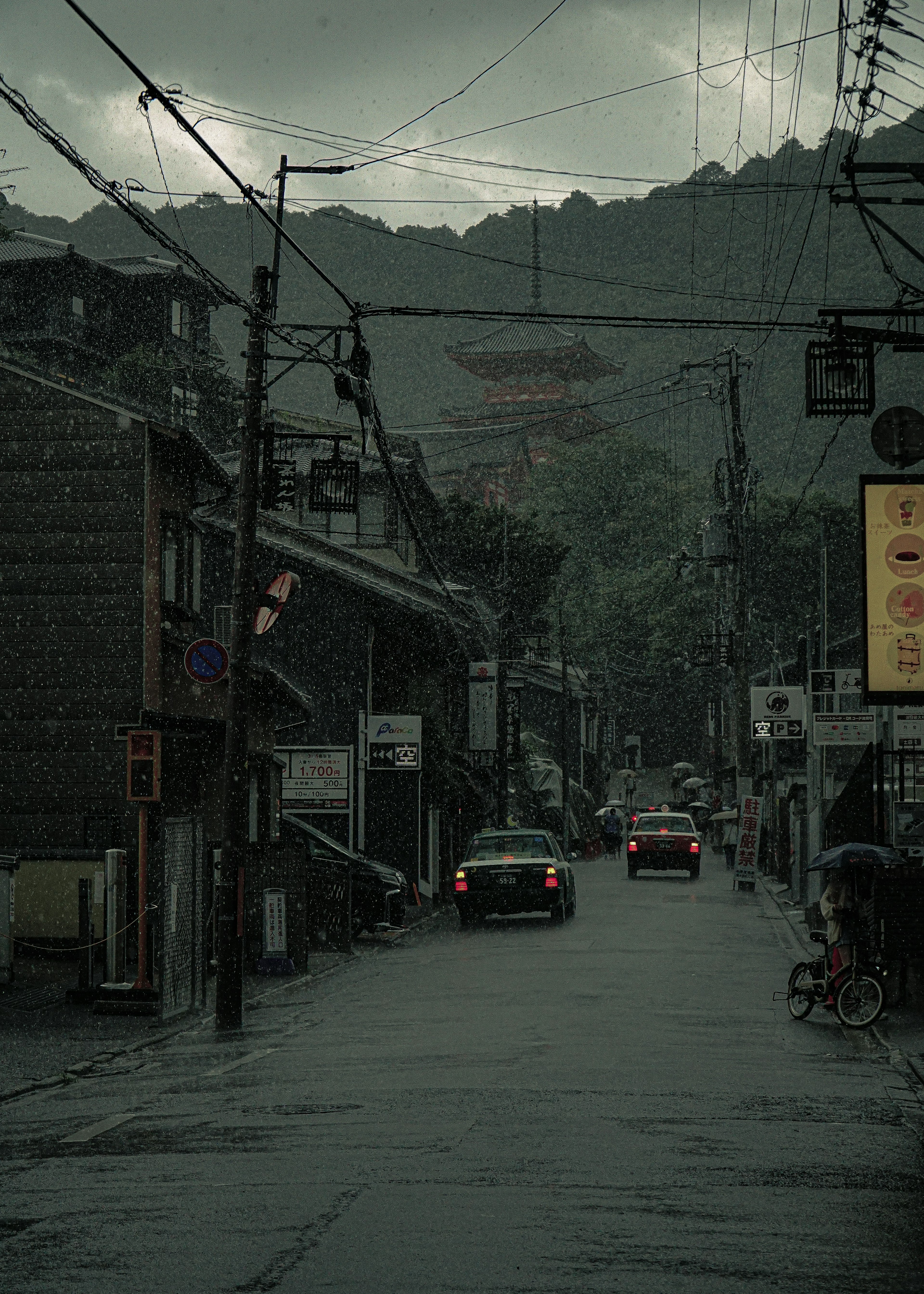 ทิวทัศน์ถนนที่มีฝนตกพร้อมรถยนต์และภูเขาในพื้นหลัง