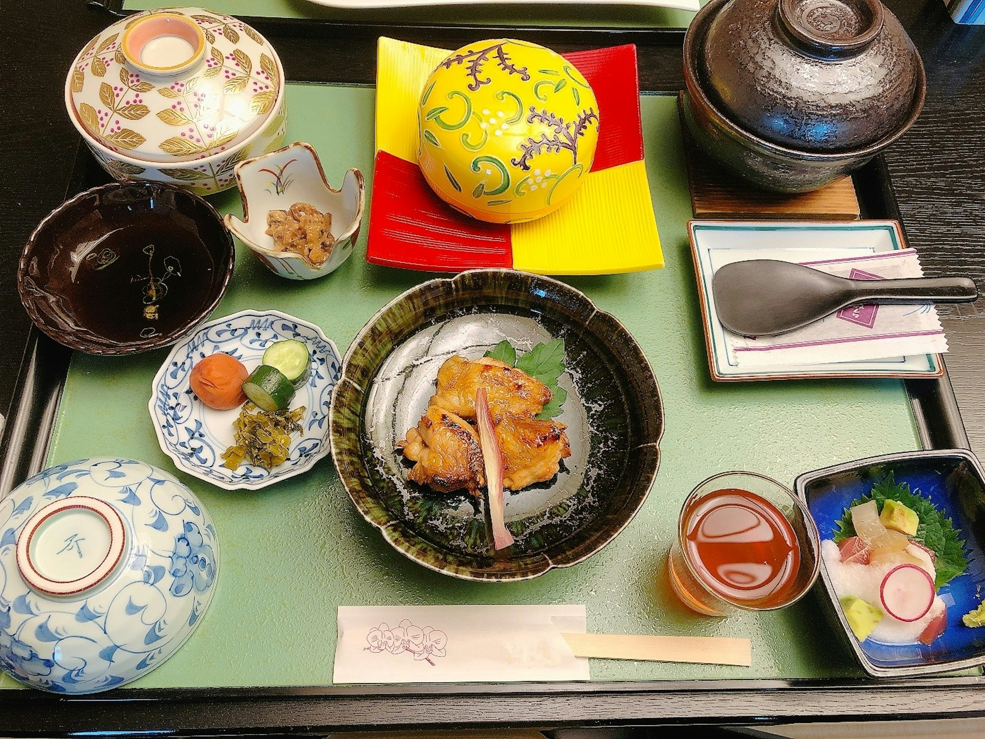 Présentation élégante de la cuisine japonaise avec du poulet grillé et des plats d'accompagnement colorés