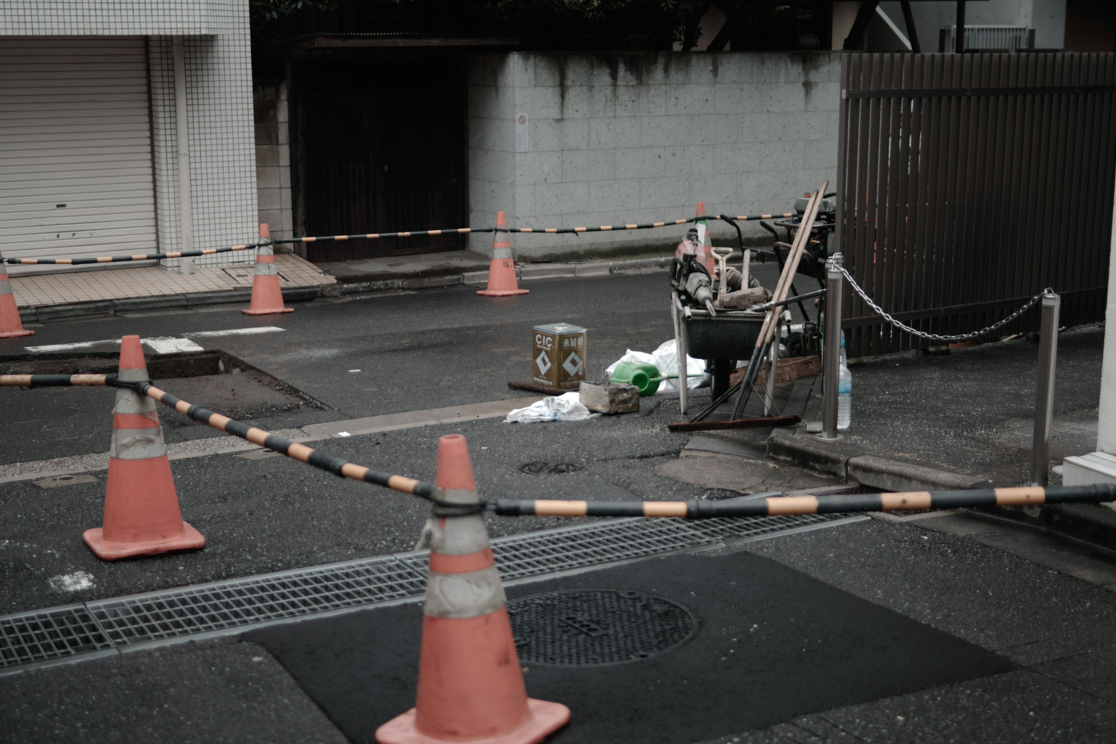 Scène de construction avec des cônes orange et des barricades dans une rue