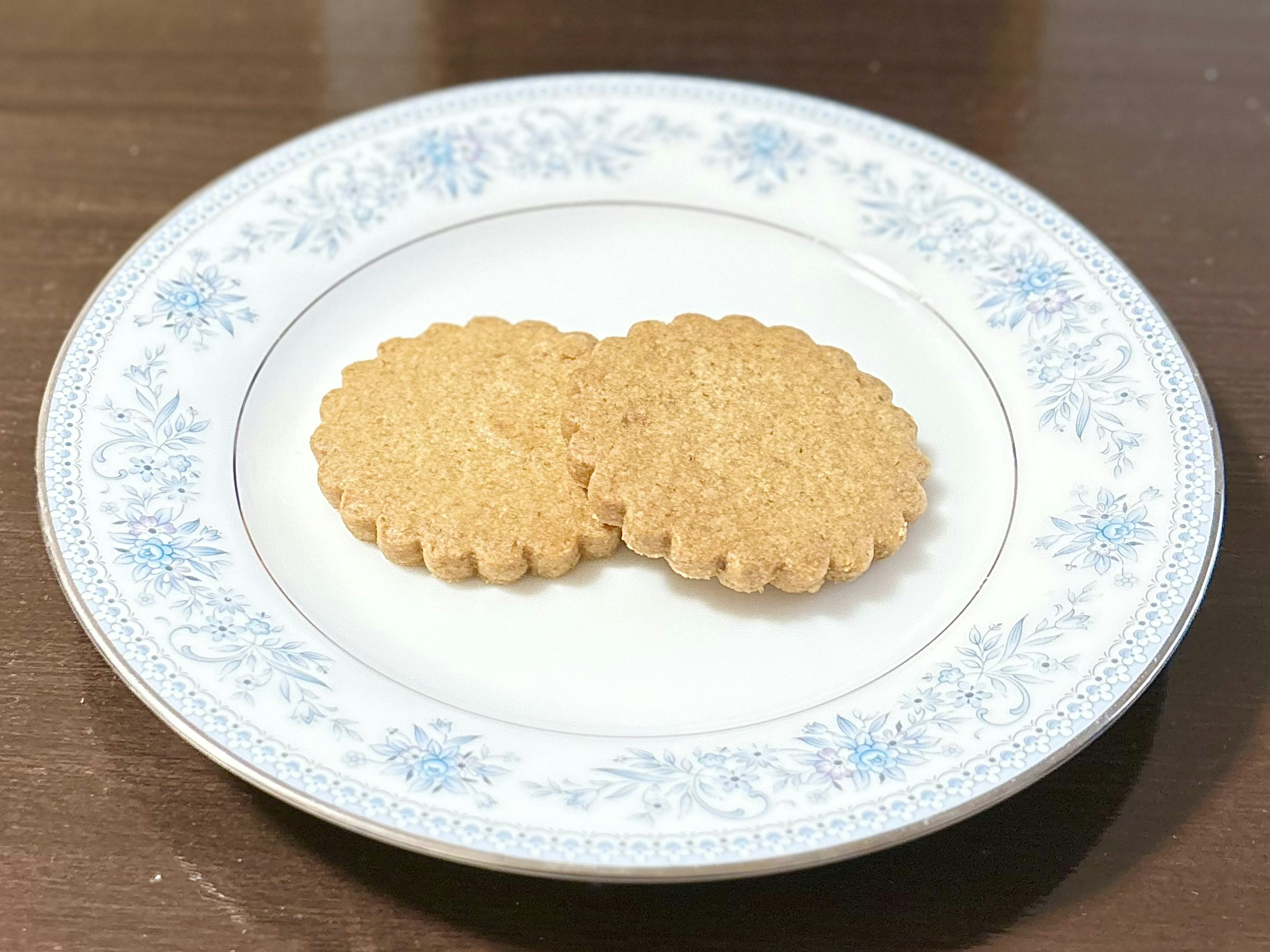 Deux biscuits ronds sur une assiette avec un motif floral bleu