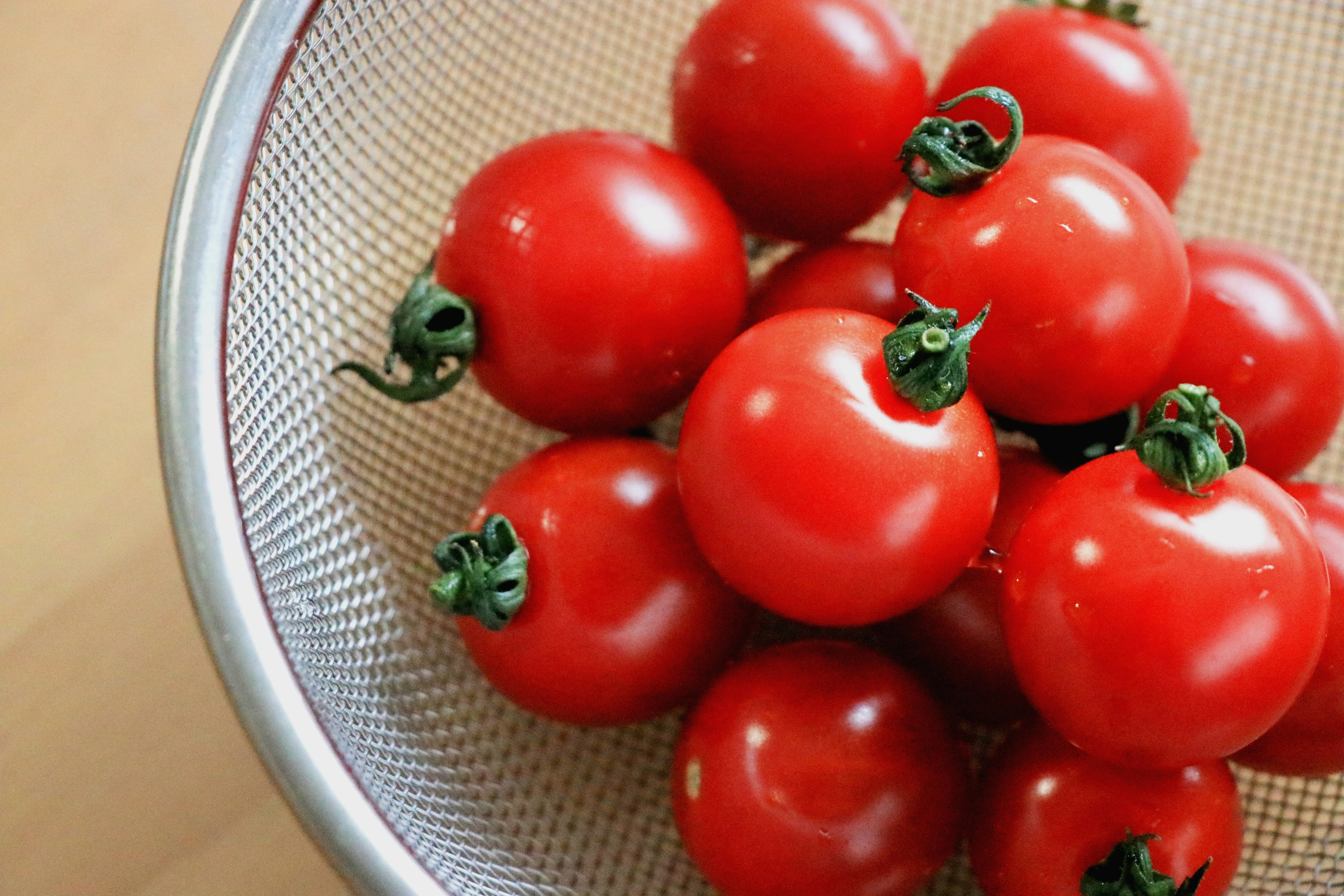 Una ciotola di pomodori rossi brillanti in uno scolapasta