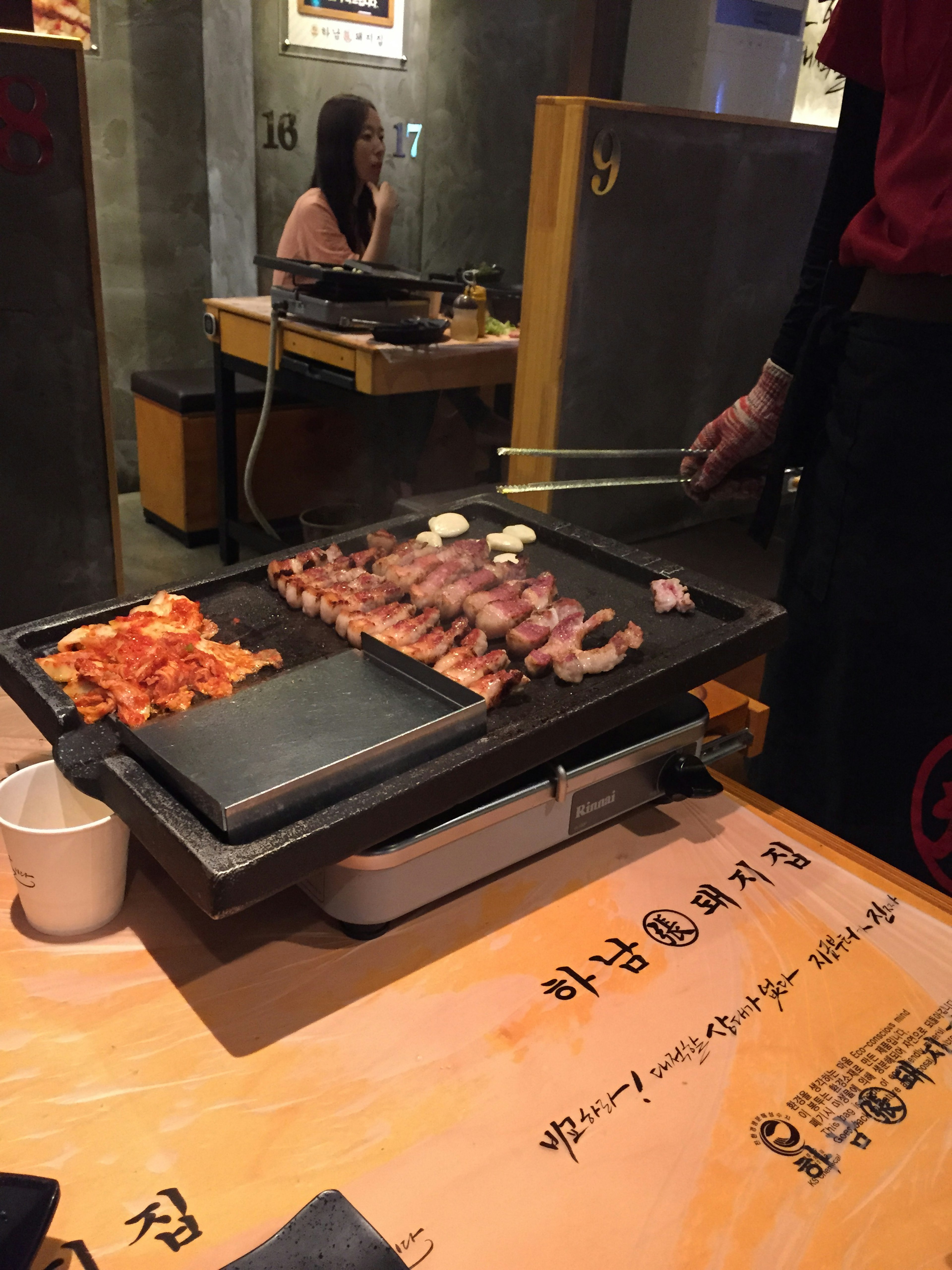 Meja dengan daging dan sayuran panggang di restoran BBQ Korea