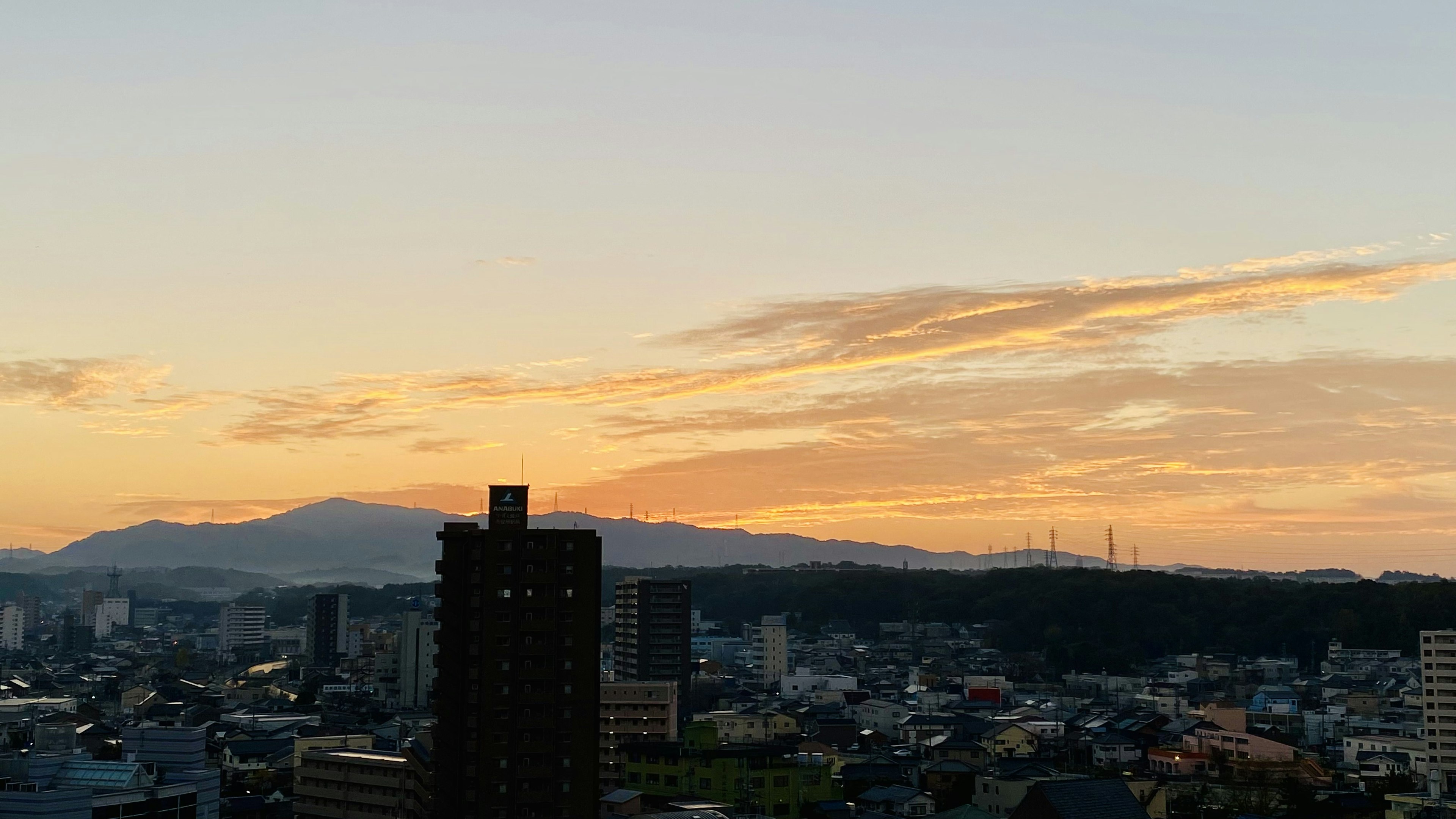 日落天空與城市景觀及背景中的山脈