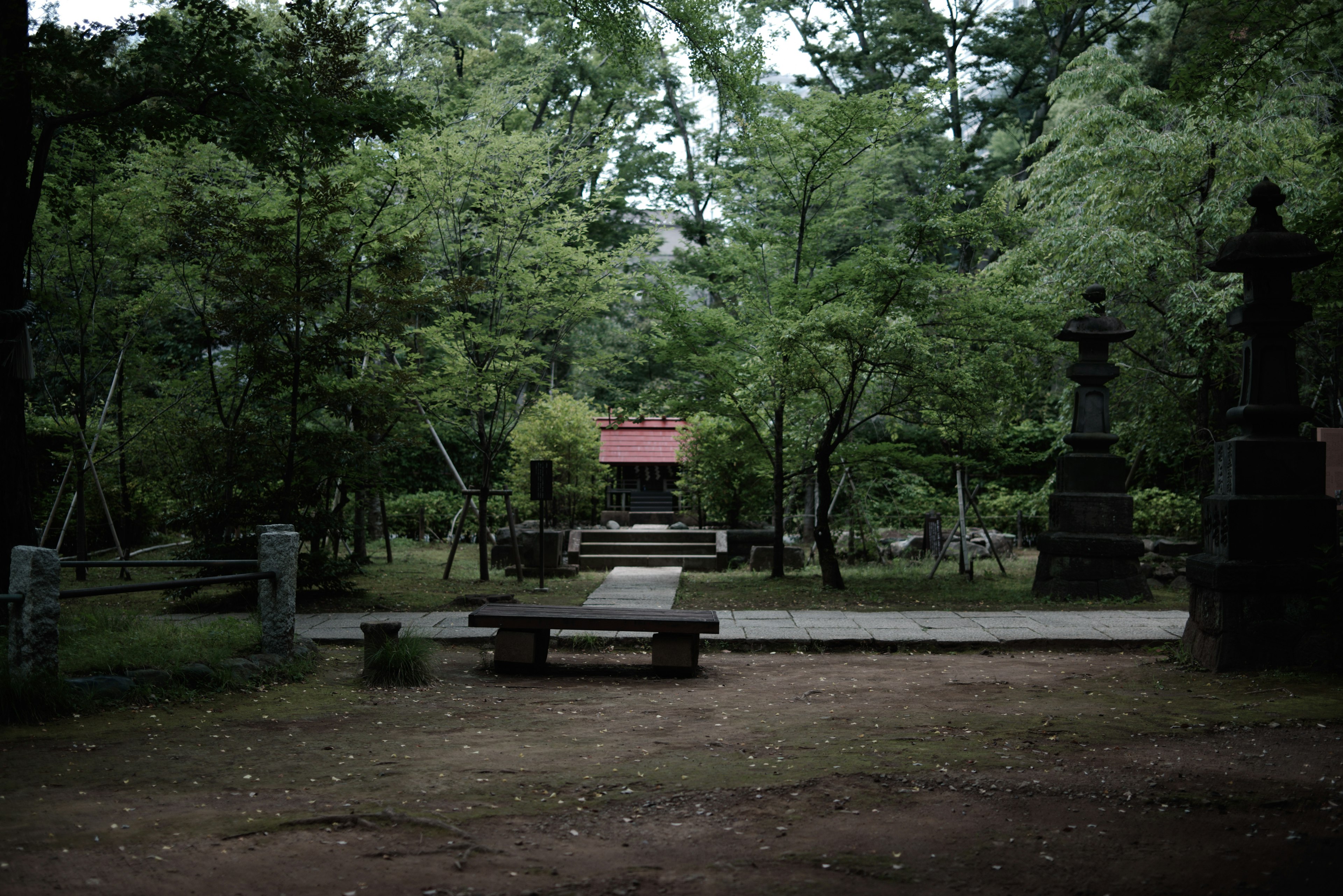 Vista serena di un santuario nella foresta con panchine e sculture in pietra