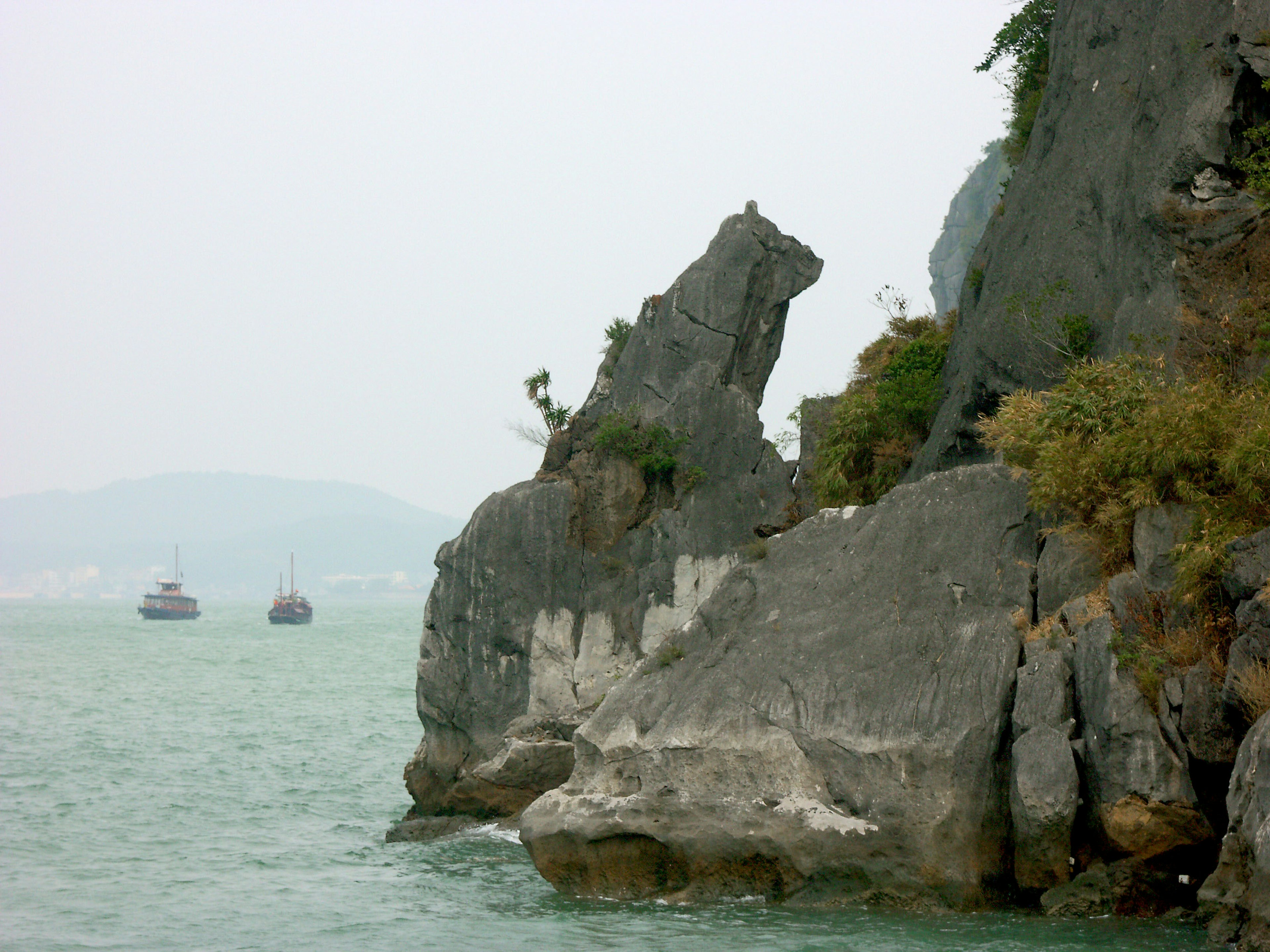 海岸風景，岩石呈馬形，遠處有船隻