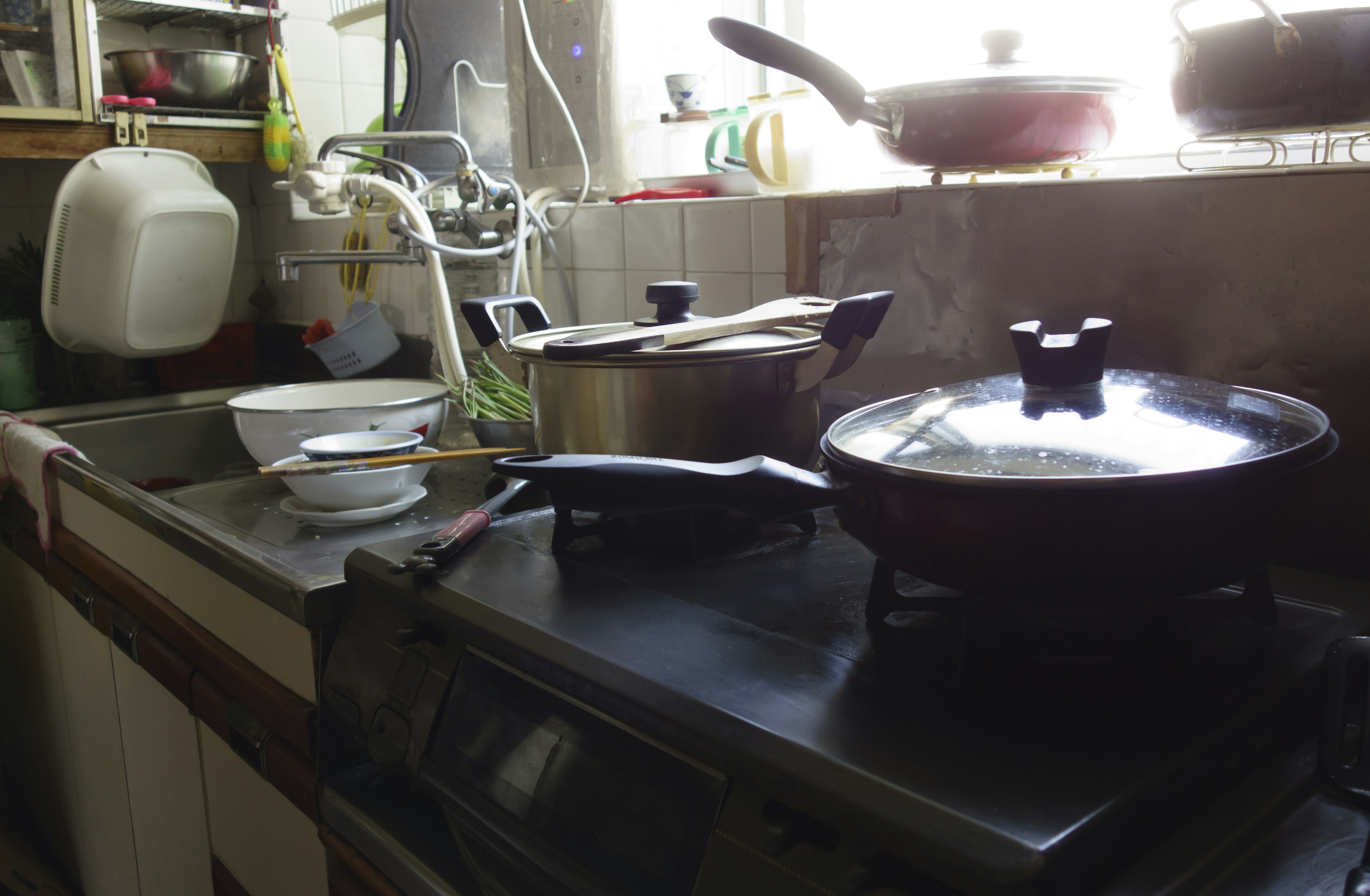 A kitchen scene featuring various pots and pans on a stove