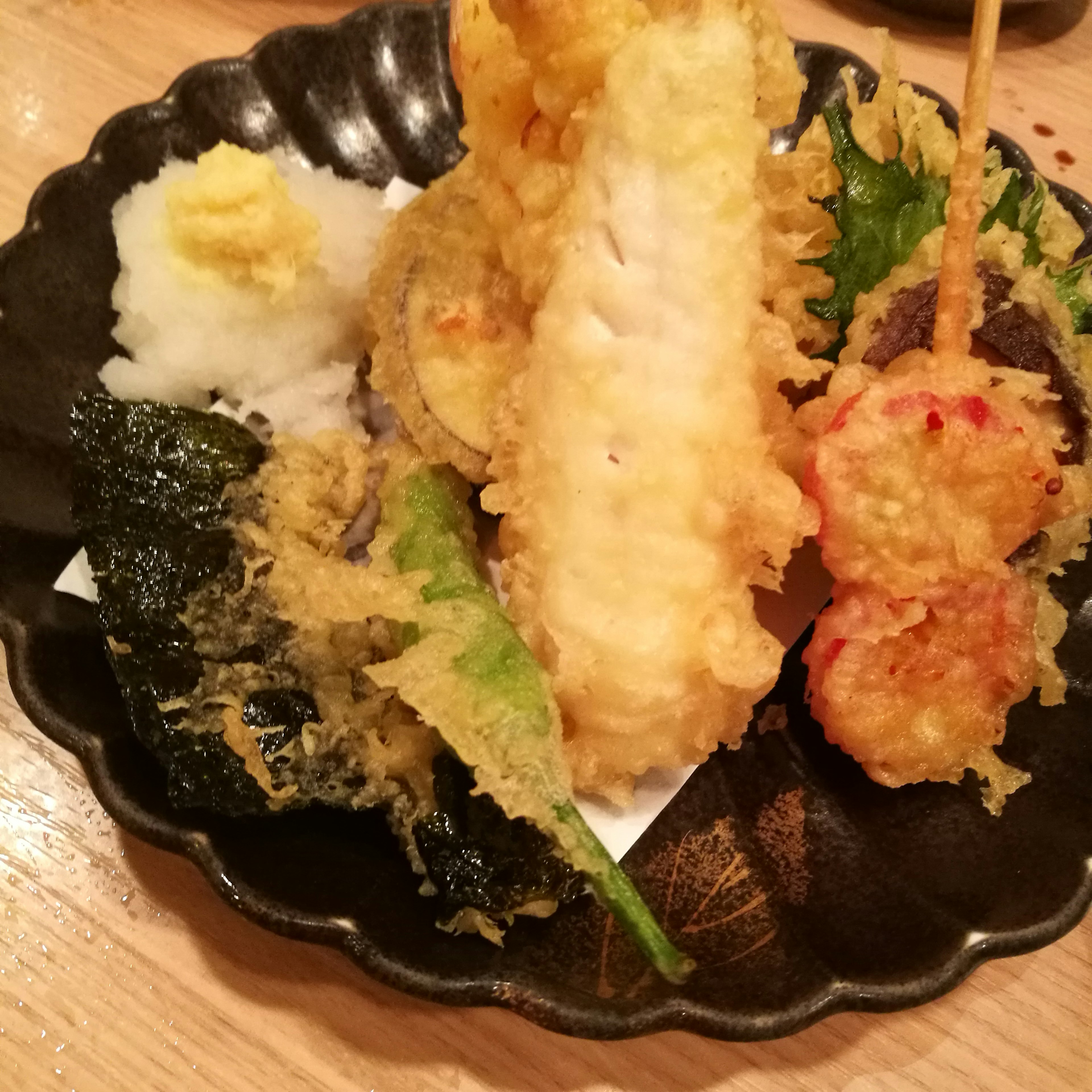 Assorted tempura served on a black plate