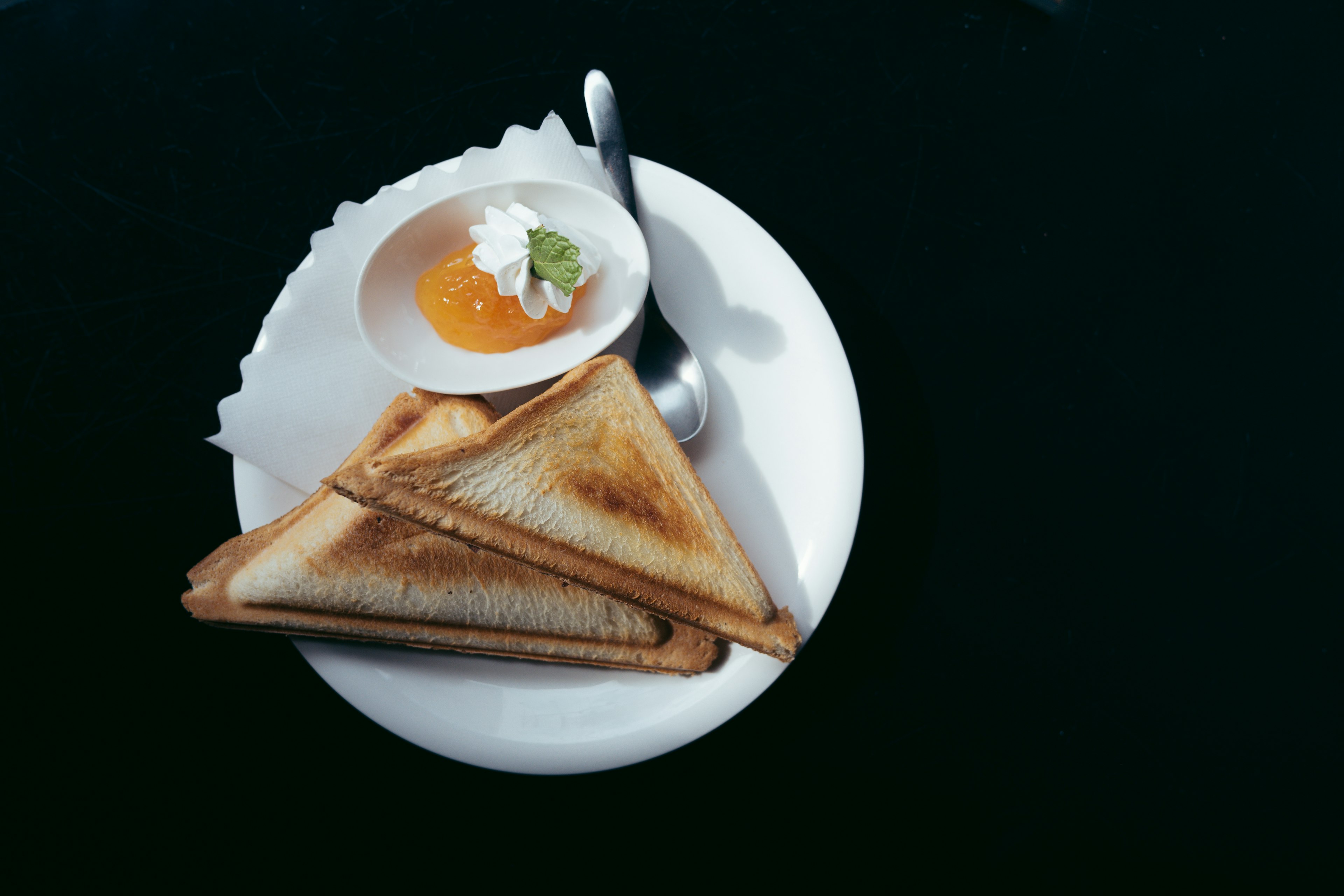 Sandwich panggang dengan saus telur di piring putih