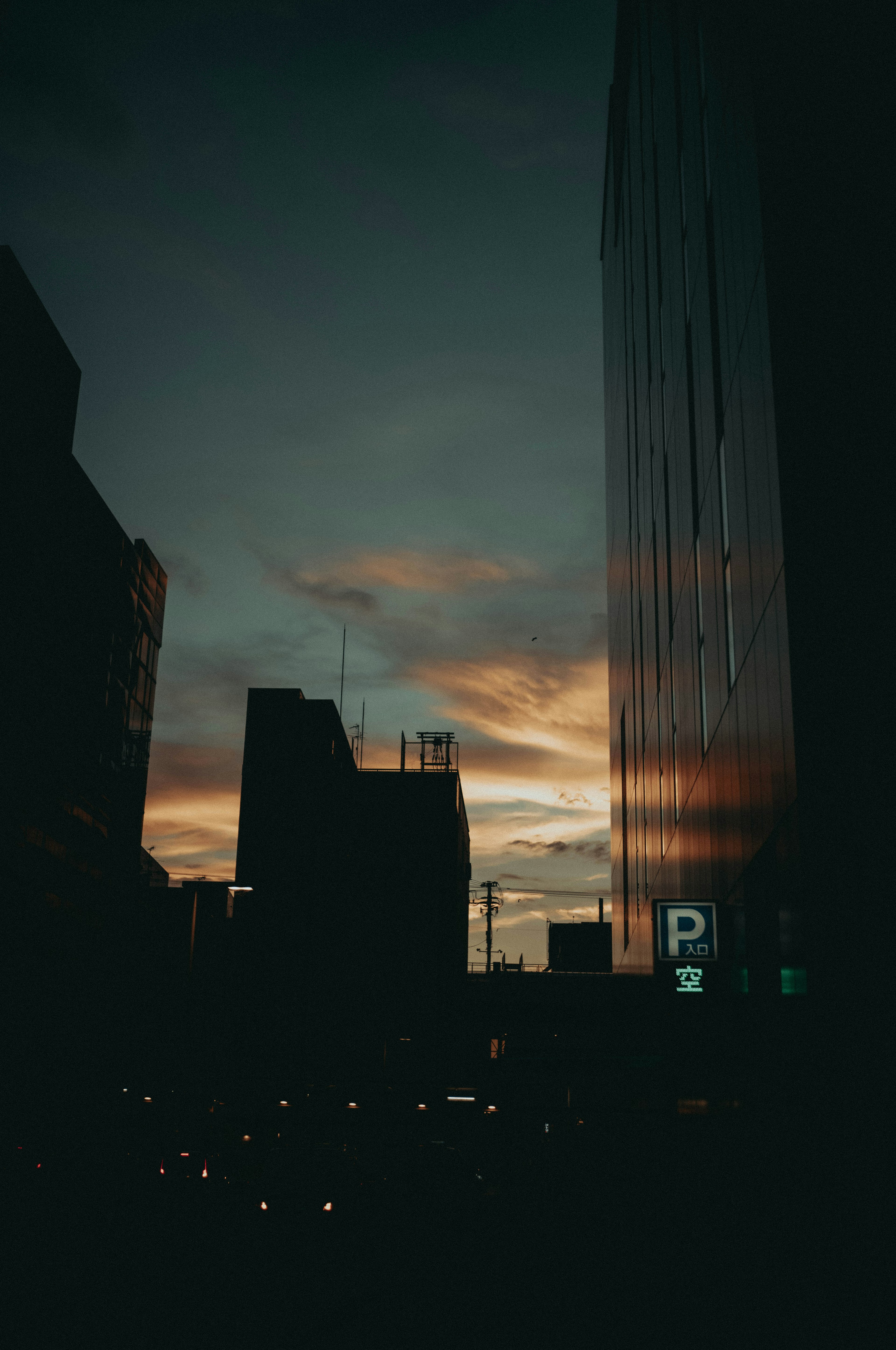 Silhouette of buildings against a sunset with reflections