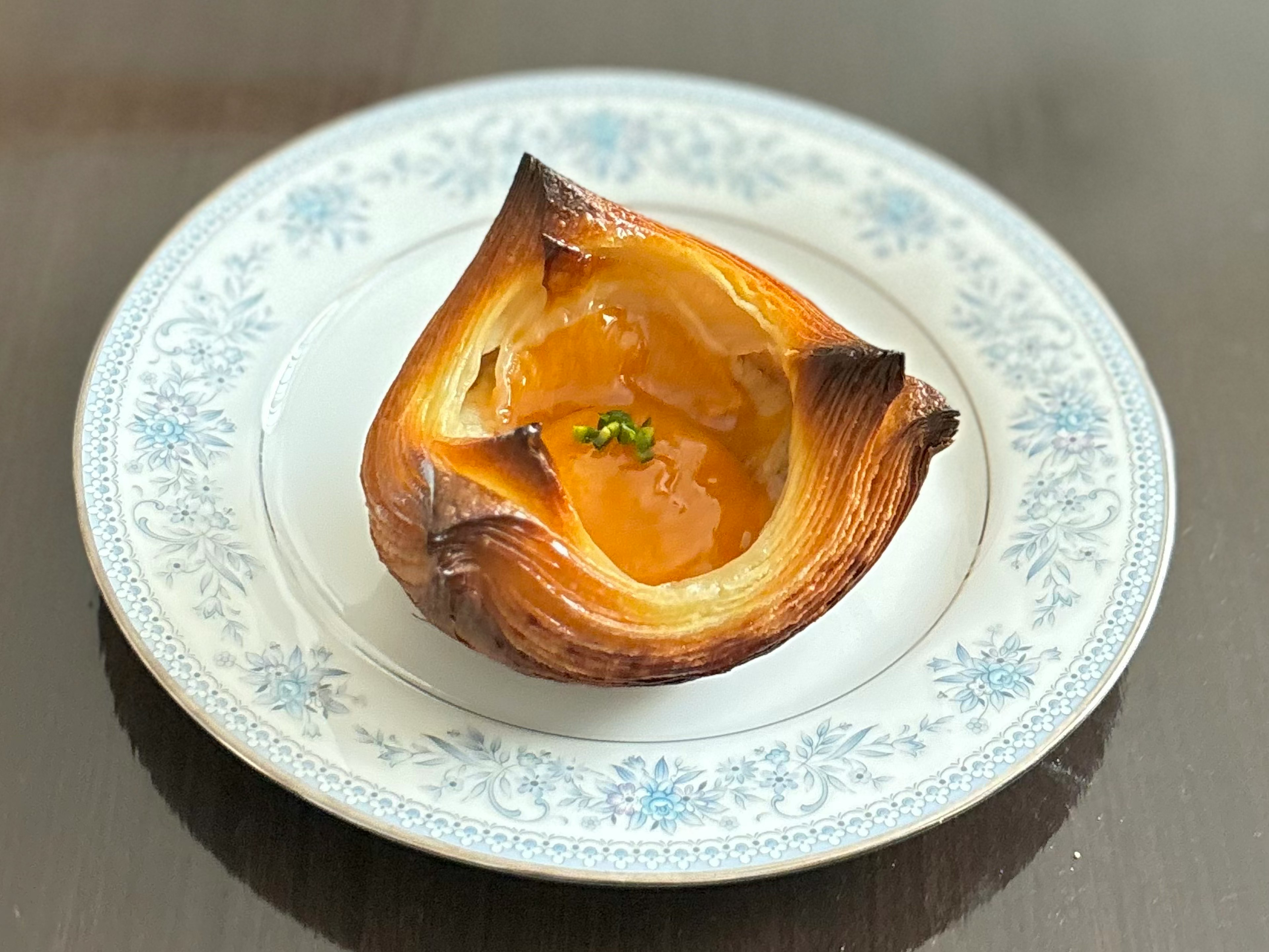 Pastelería recién horneada con relleno naranja en un plato decorativo