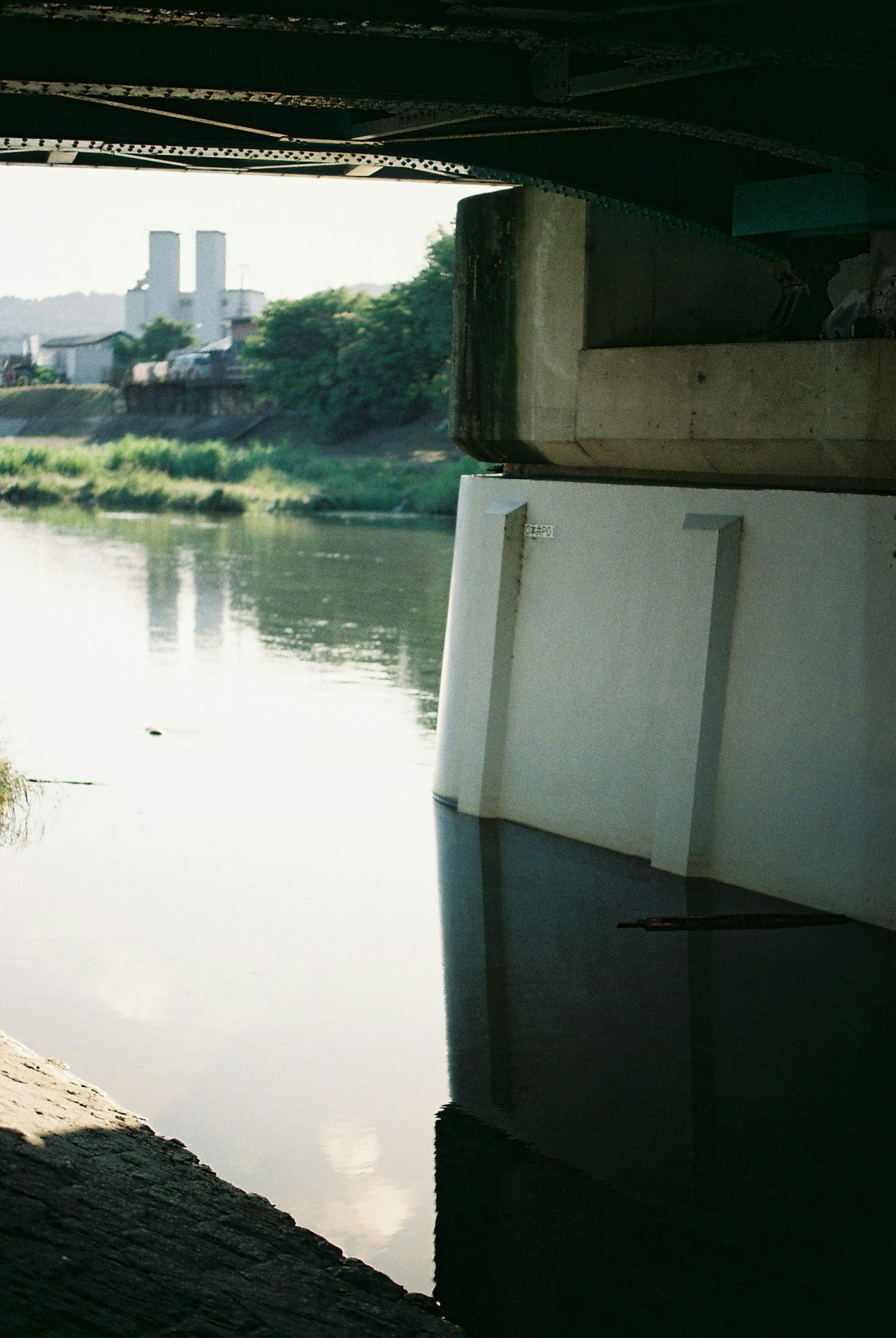 Vista tranquilla del fiume da sotto un ponte con riflessi