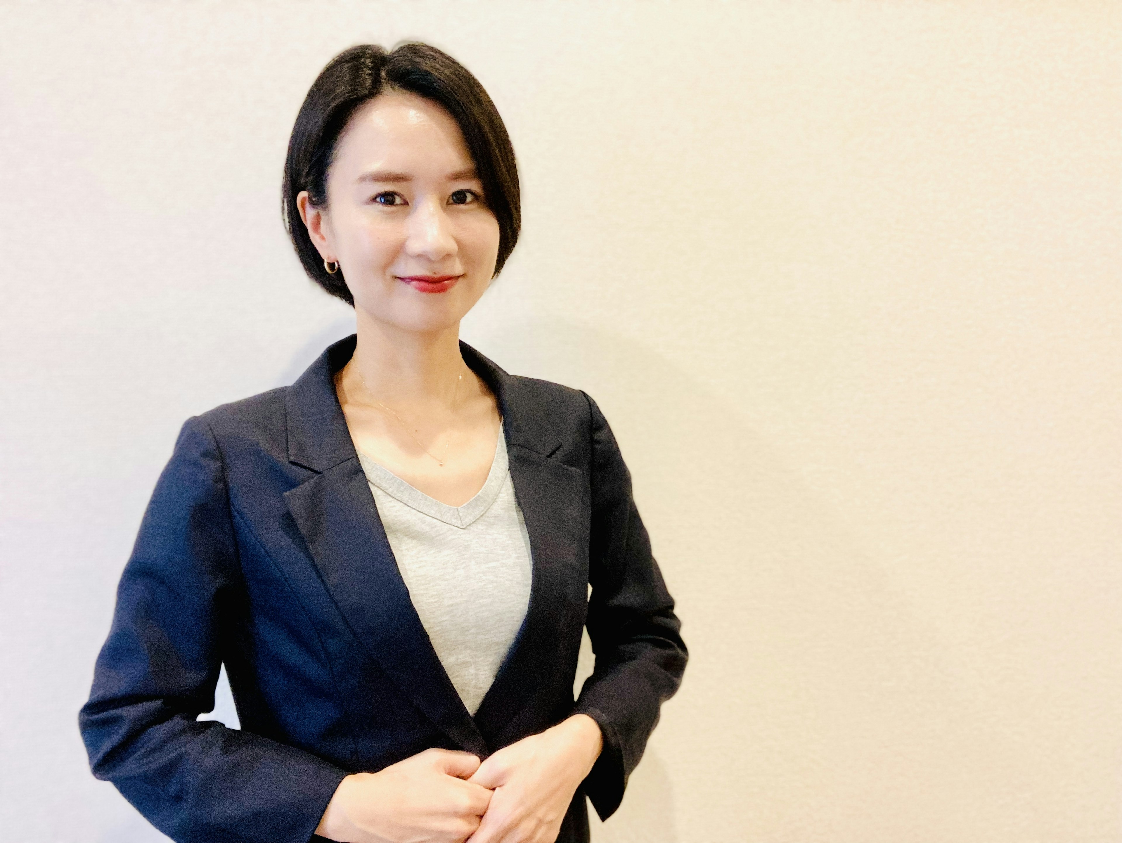 A woman in a business suit smiling confidently