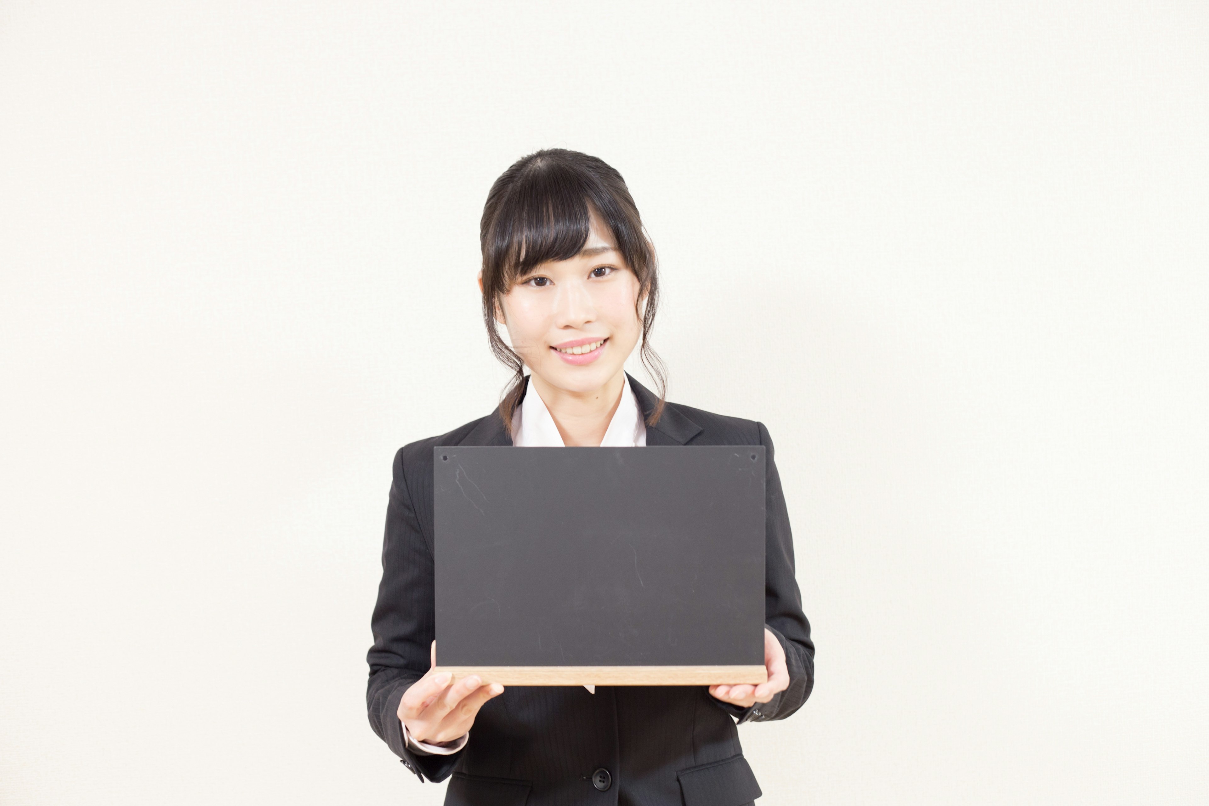 Woman in business suit holding a black laptop