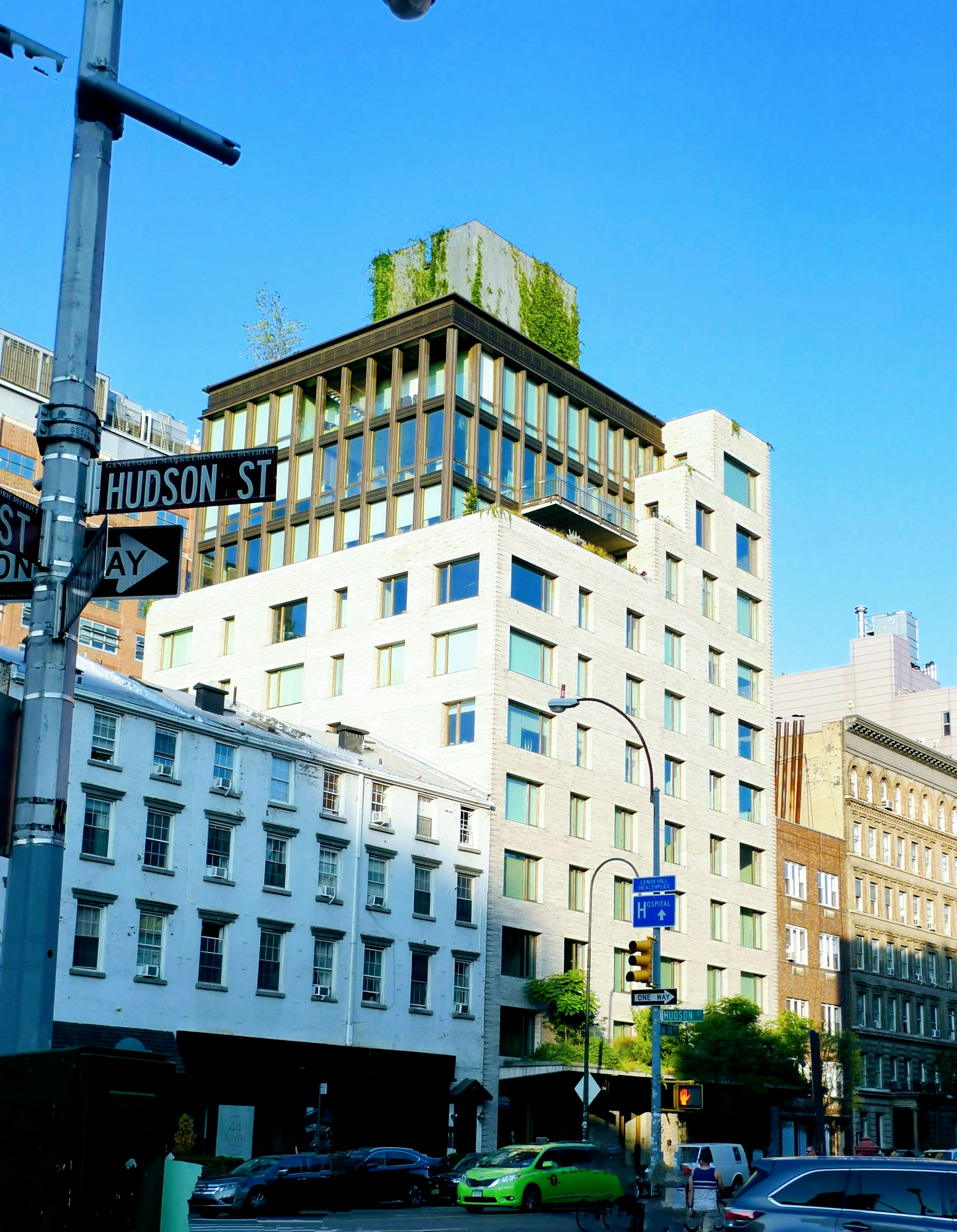 Edificio moderno su Hudson Street con vegetazione e cielo blu