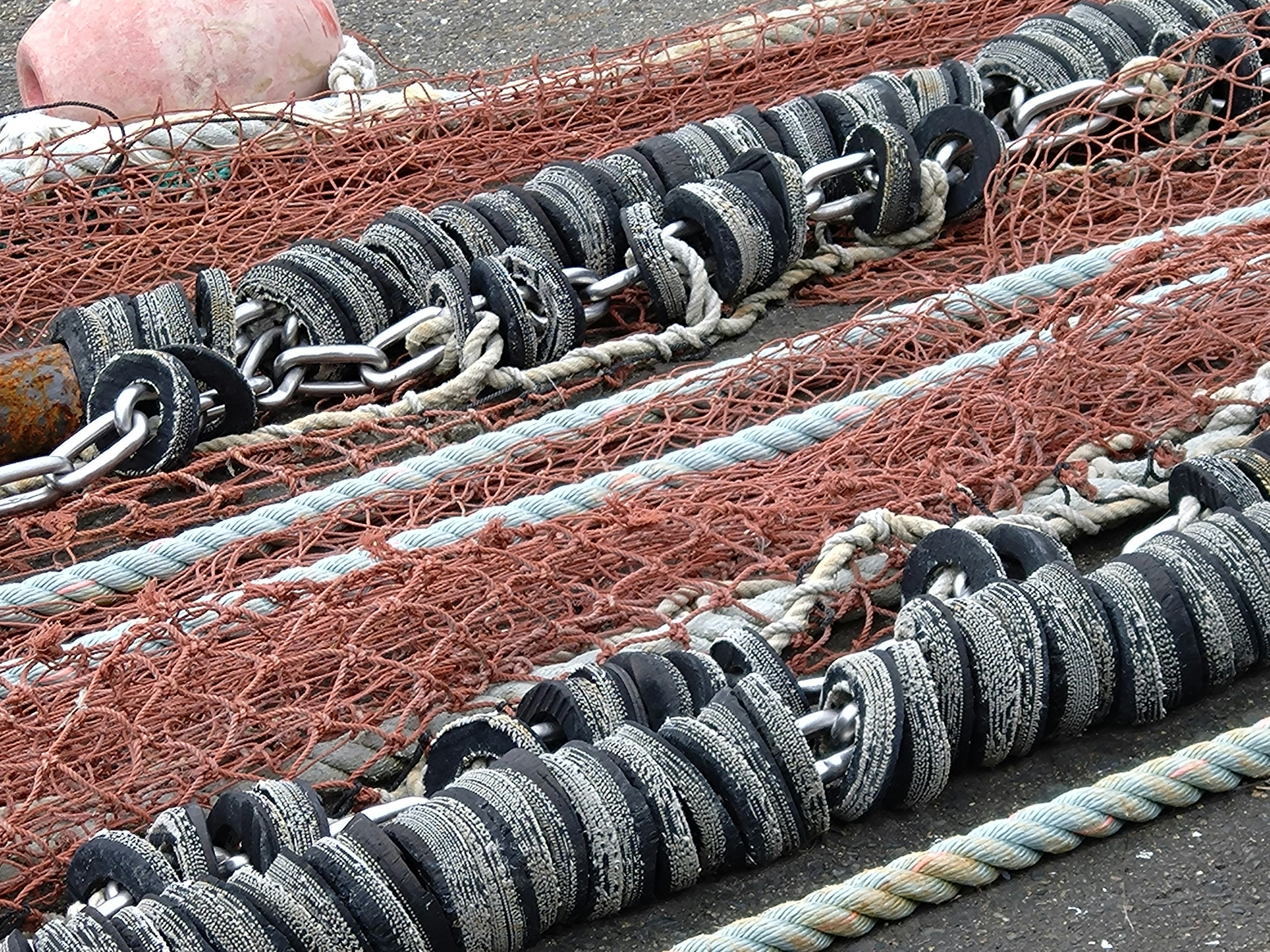 A coastal scene featuring fishing nets and weights lined up