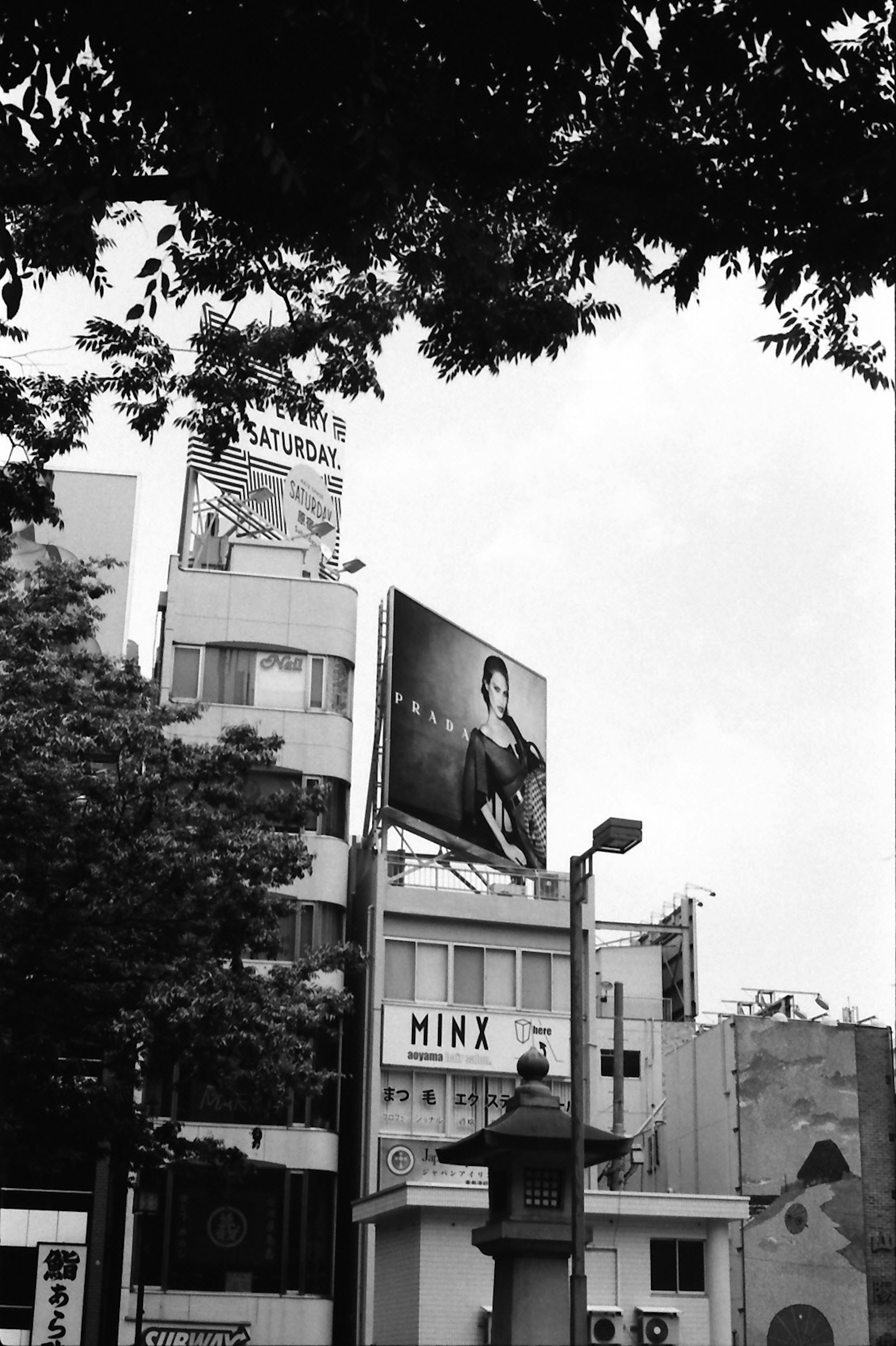 Foto hitam putih dari gedung tinggi dengan papan iklan yang menampilkan seseorang