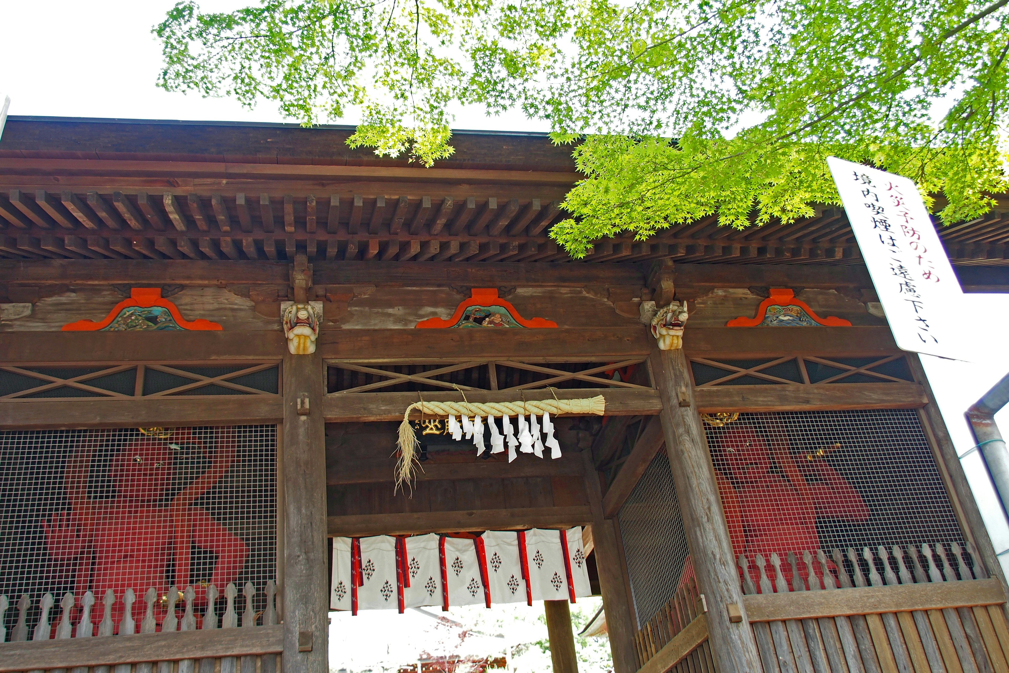 Traditional Japanese shrine gate with red decorations and hanging shide