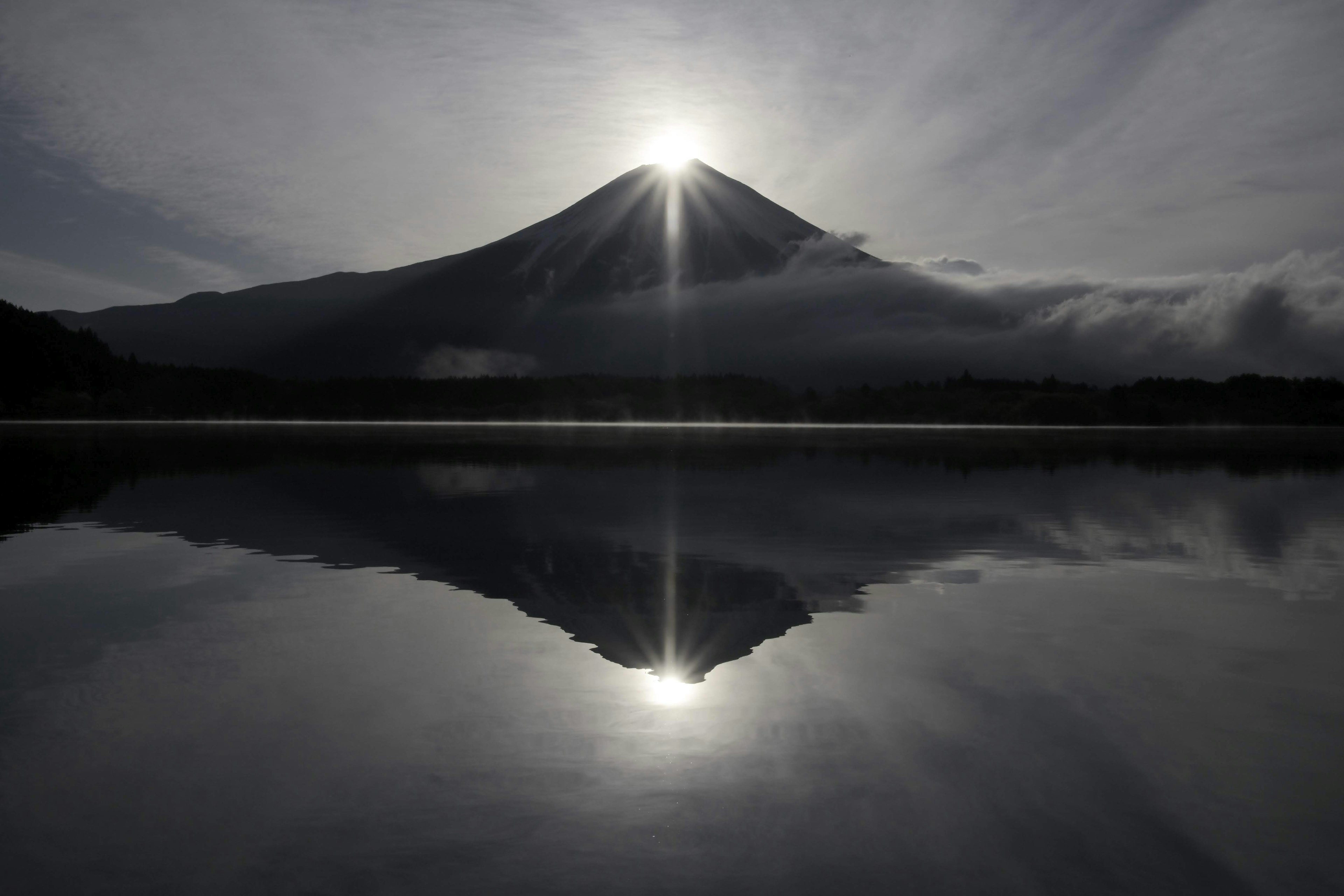 富士山のシルエットが湖面に映り込む美しい風景