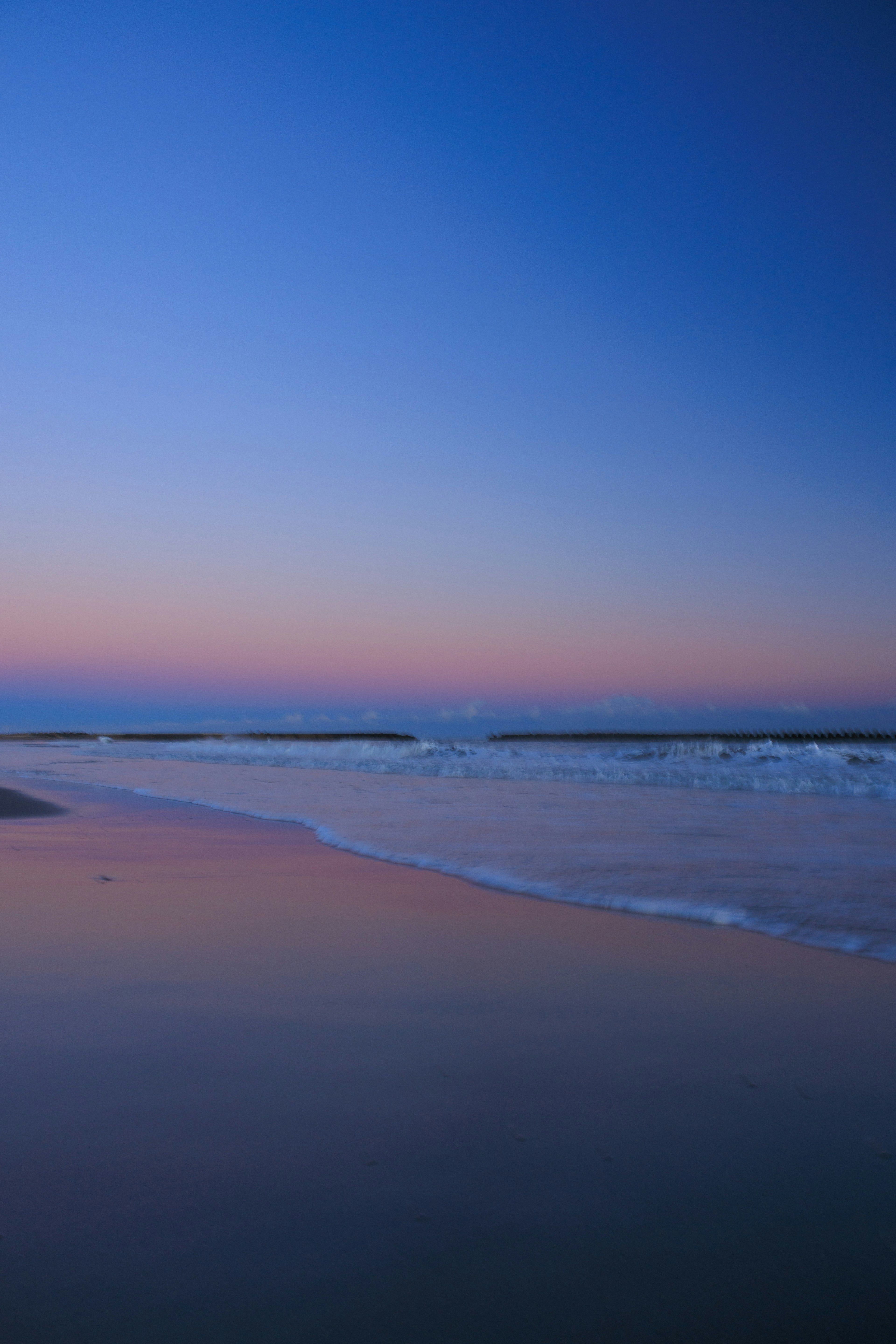 Scène de plage sereine avec un ciel dégradé et des vagues douces