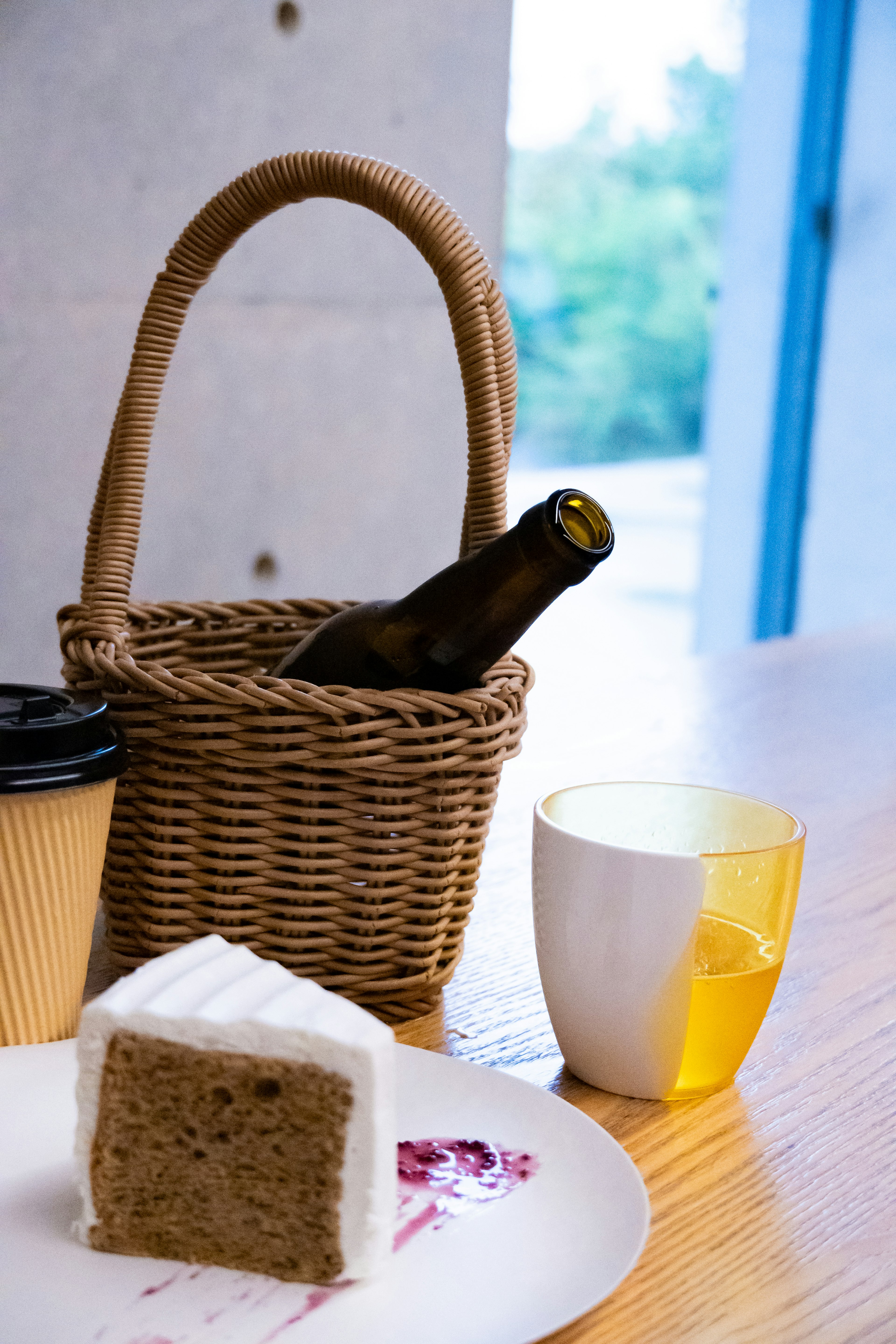 Mesa con una cesta que contiene cerveza y una porción de pastel