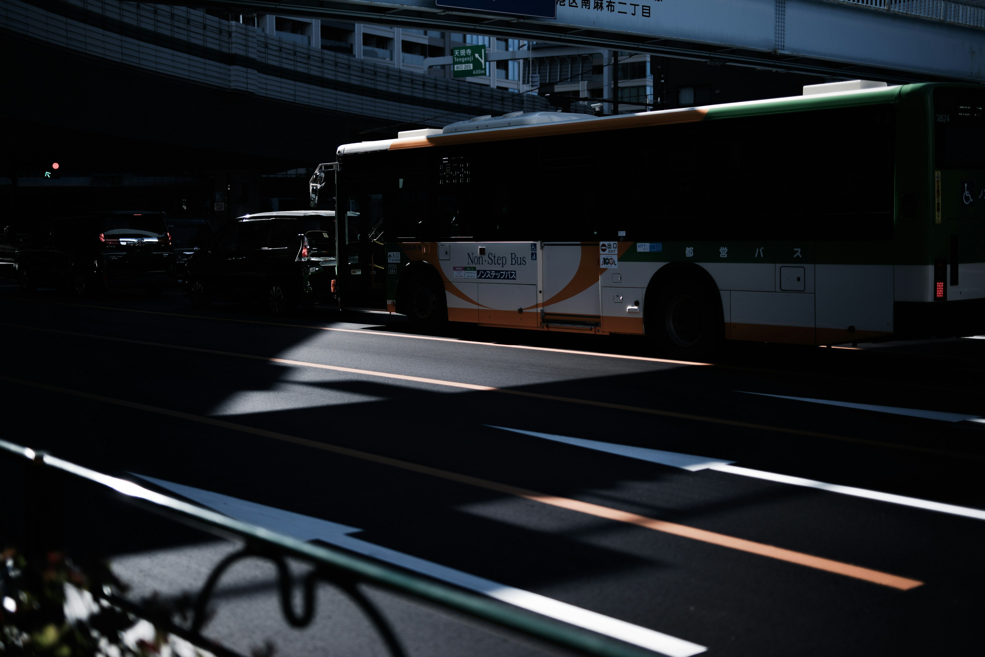 暗い道路に停車中のバスと影のコントラスト