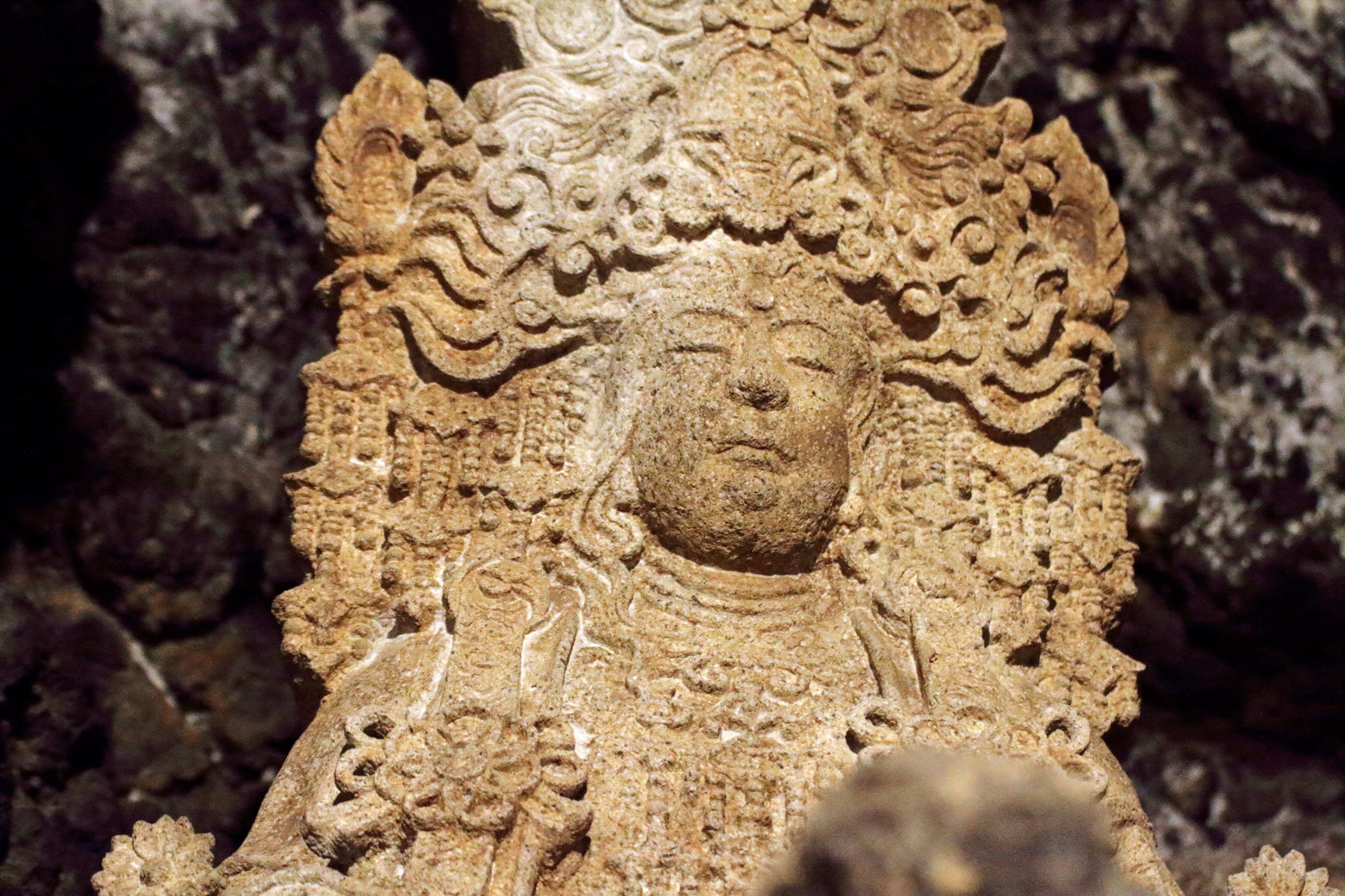 Escultura de piedra de una deidad visible en una cueva