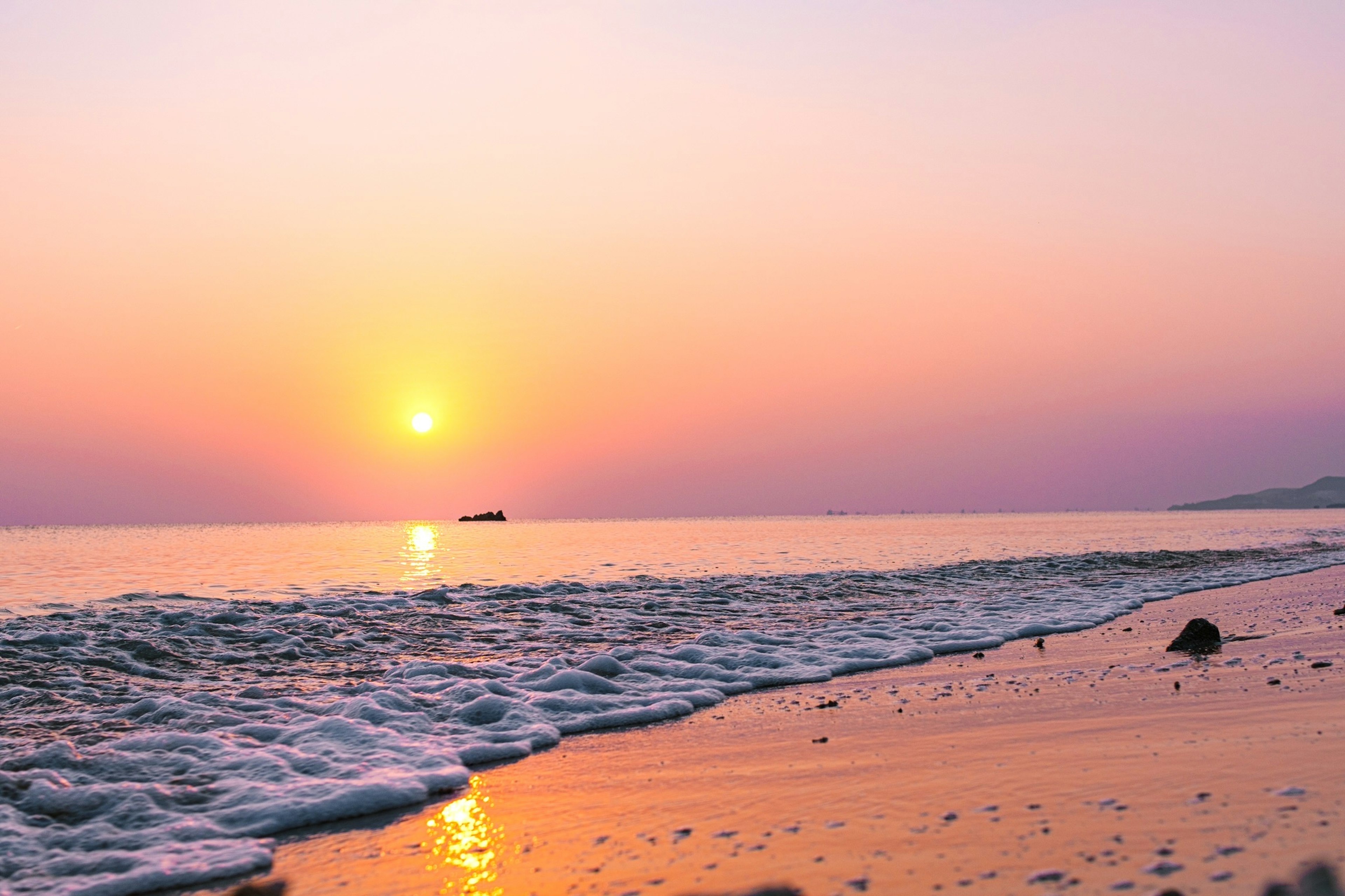 夕日が海に沈む美しいビーチの風景